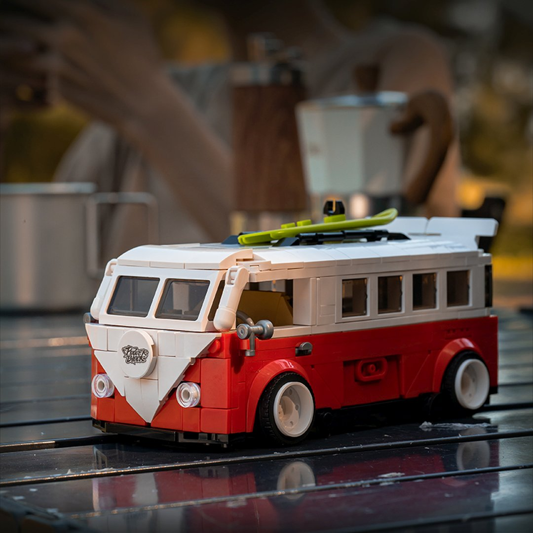 Czerwony i biały autobus Lego z deskorolką na dachu stoi na zewnątrz.