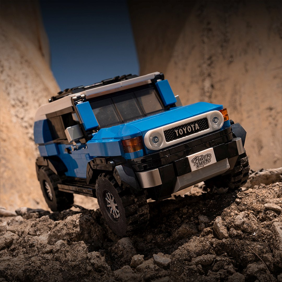 Niebiesko-biały Lego Toyota FJ Cruiser jedzie po skalistym terenie.