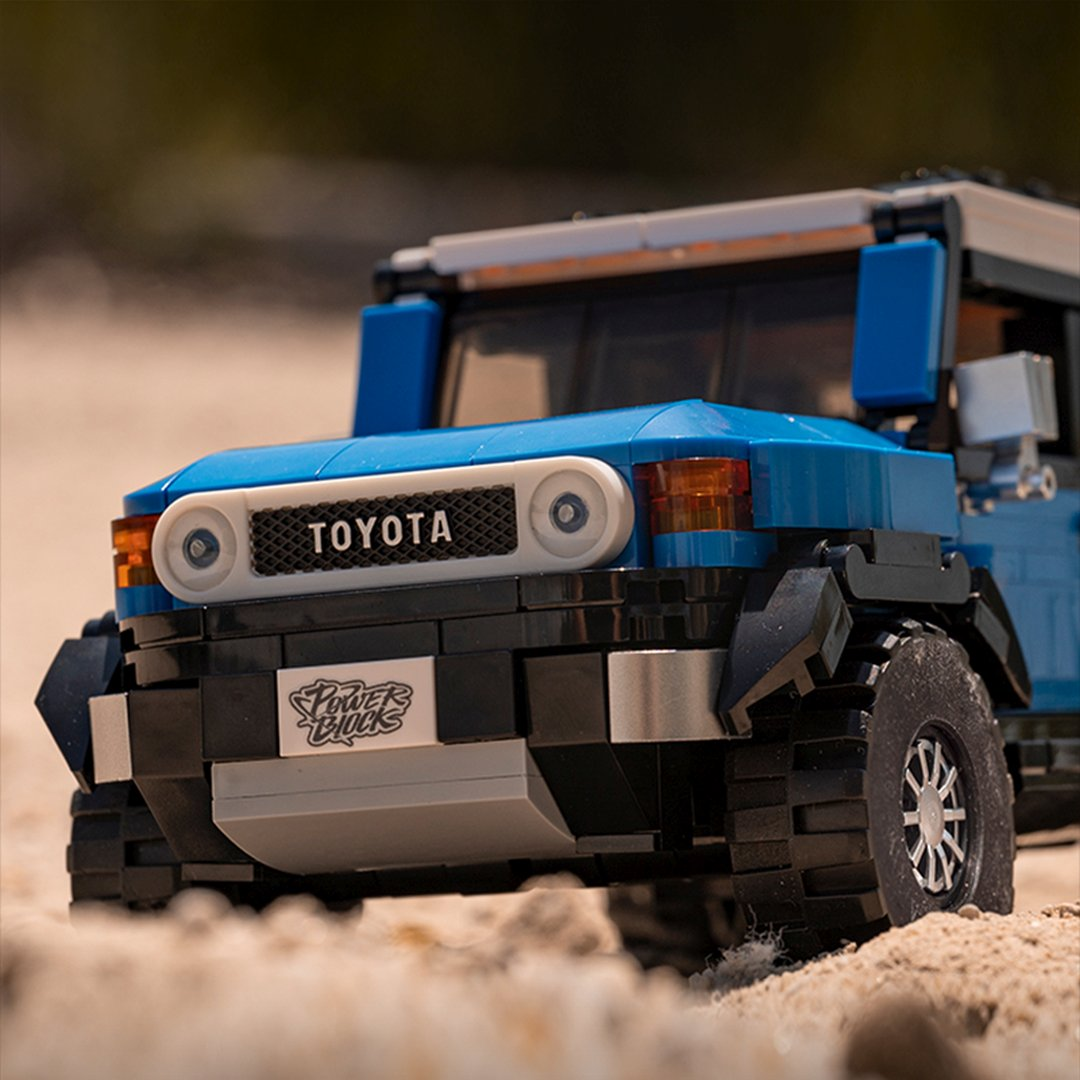 Niebieski SUV Lego z napisem "Toyota" na piaszczystej powierzchni.