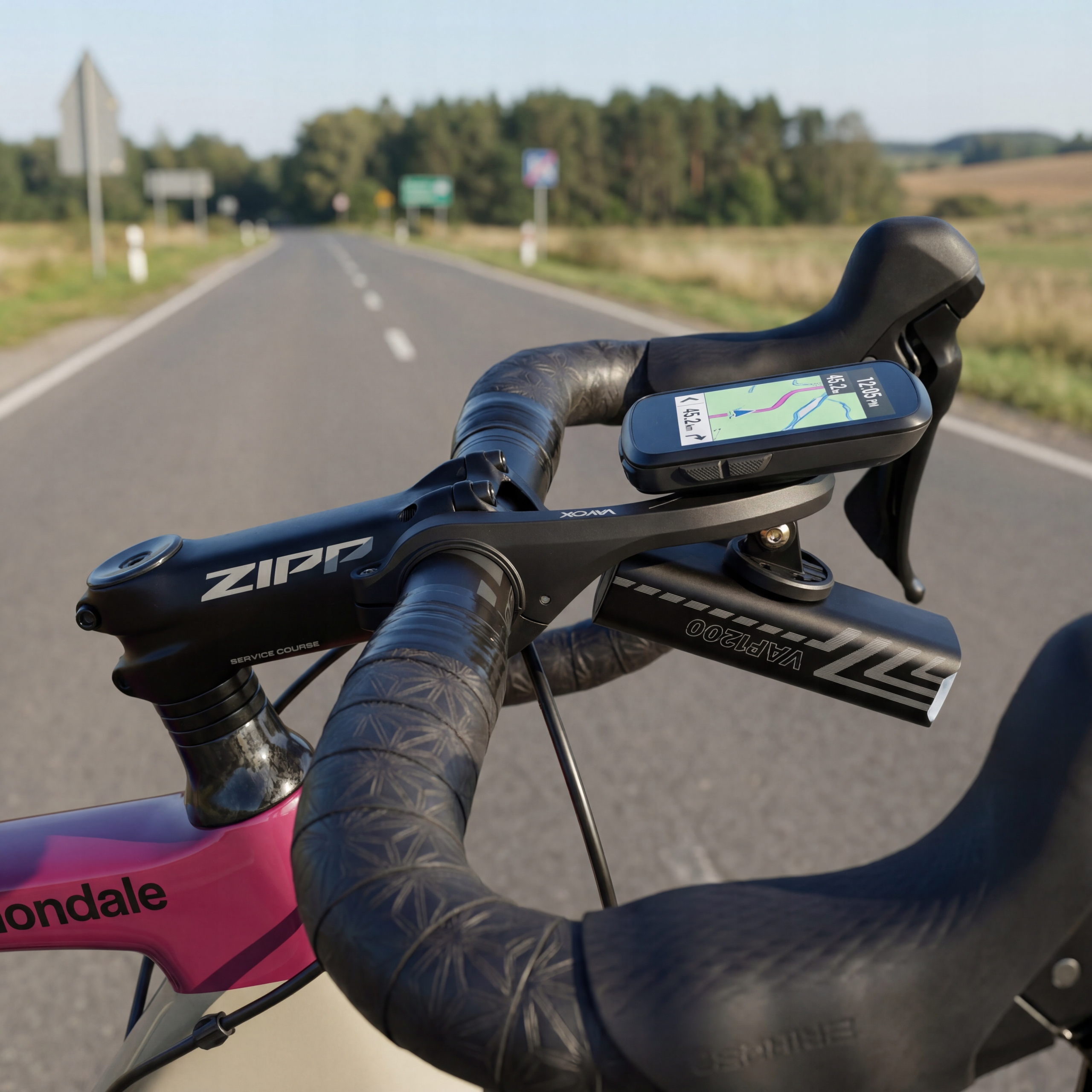 Kierownica roweru z urządzeniem GPS i światłem na drodze.