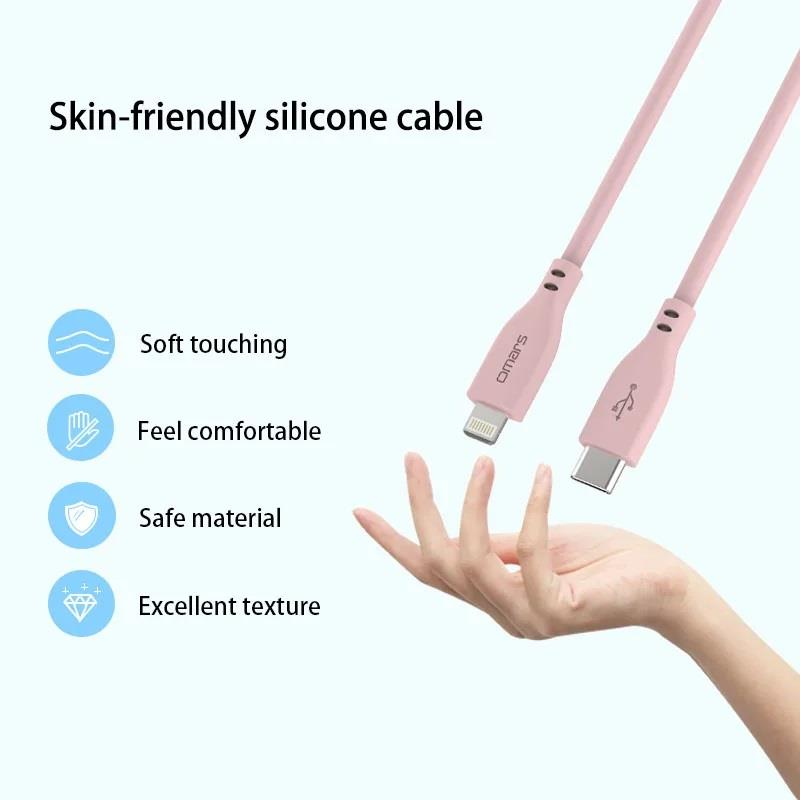 Elinde tutulan USB-C ve Lightning konnektörlü pembe silikon kablolar.