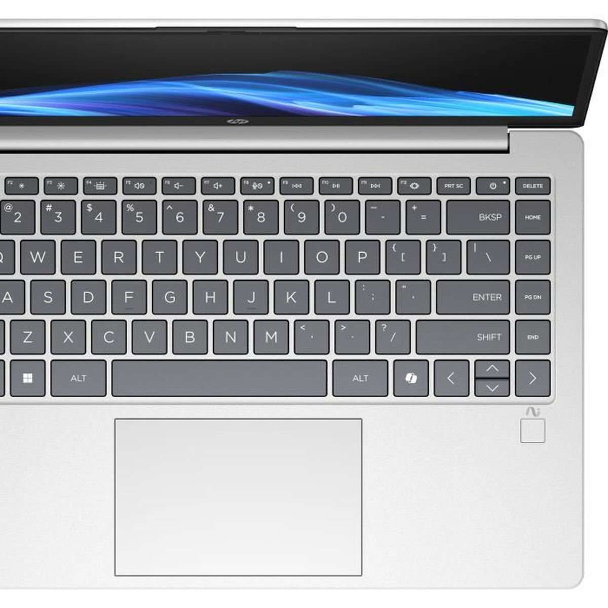 Un ordinateur portable argenté avec l'écran ouvert, montrant le clavier et le pavé tactile.