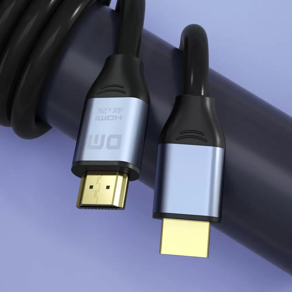 Altın kaplama konektörlü iki HDMI kablosu koyu bir silindirin üzerinde duruyor.
