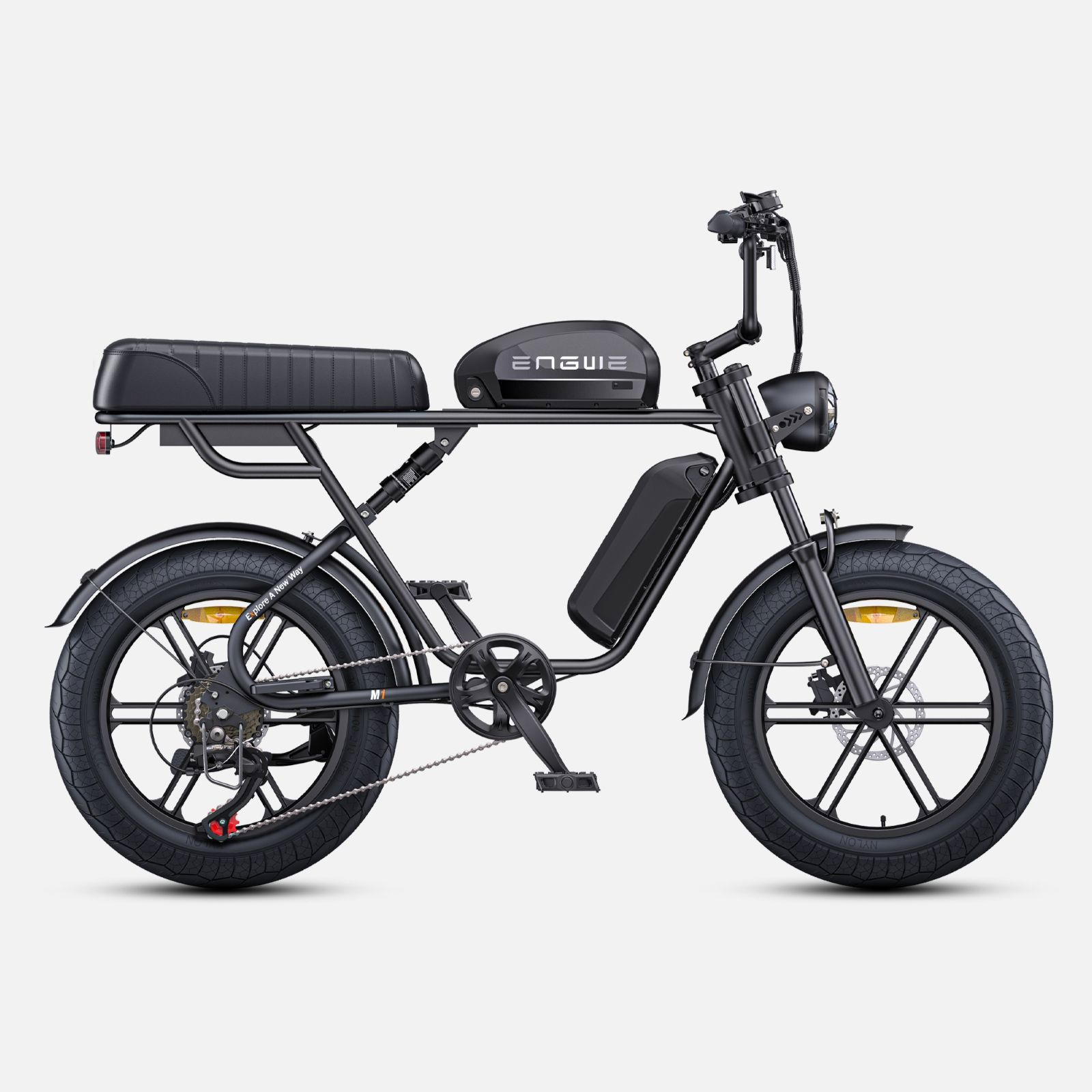 Bicicleta eléctrica negra con asiento acolchado, batería y frenos de disco sobre fondo blanco.