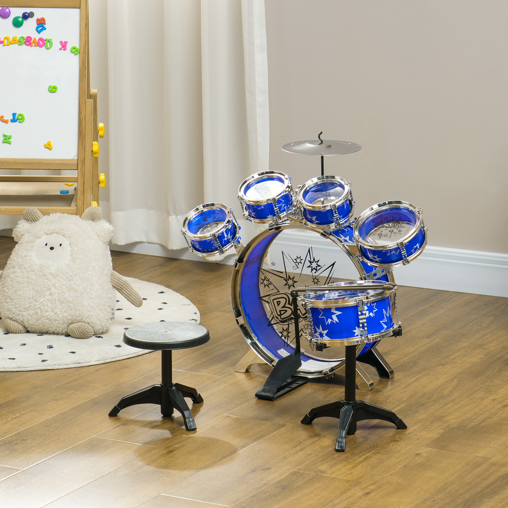 Un set di batteria per bambini con tamburi blu e accenti argentati è posato su un pavimento in legno.