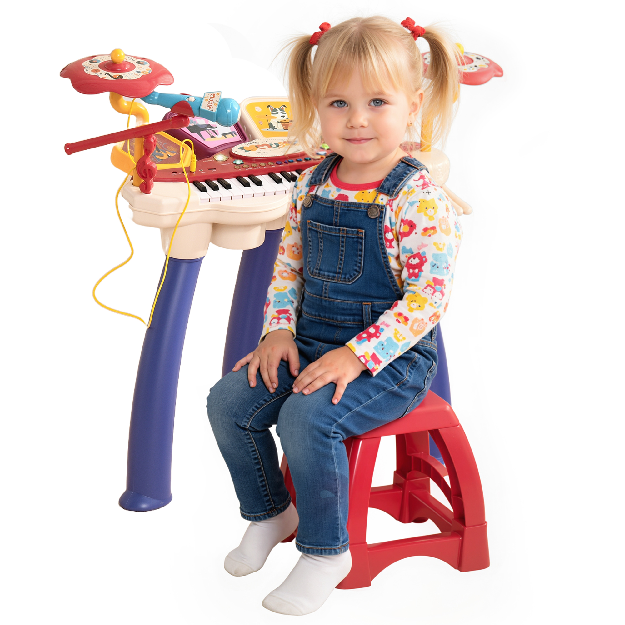 Una bambina con le code di cavallo siede su uno sgabello rosso davanti a una tastiera giocattolo.