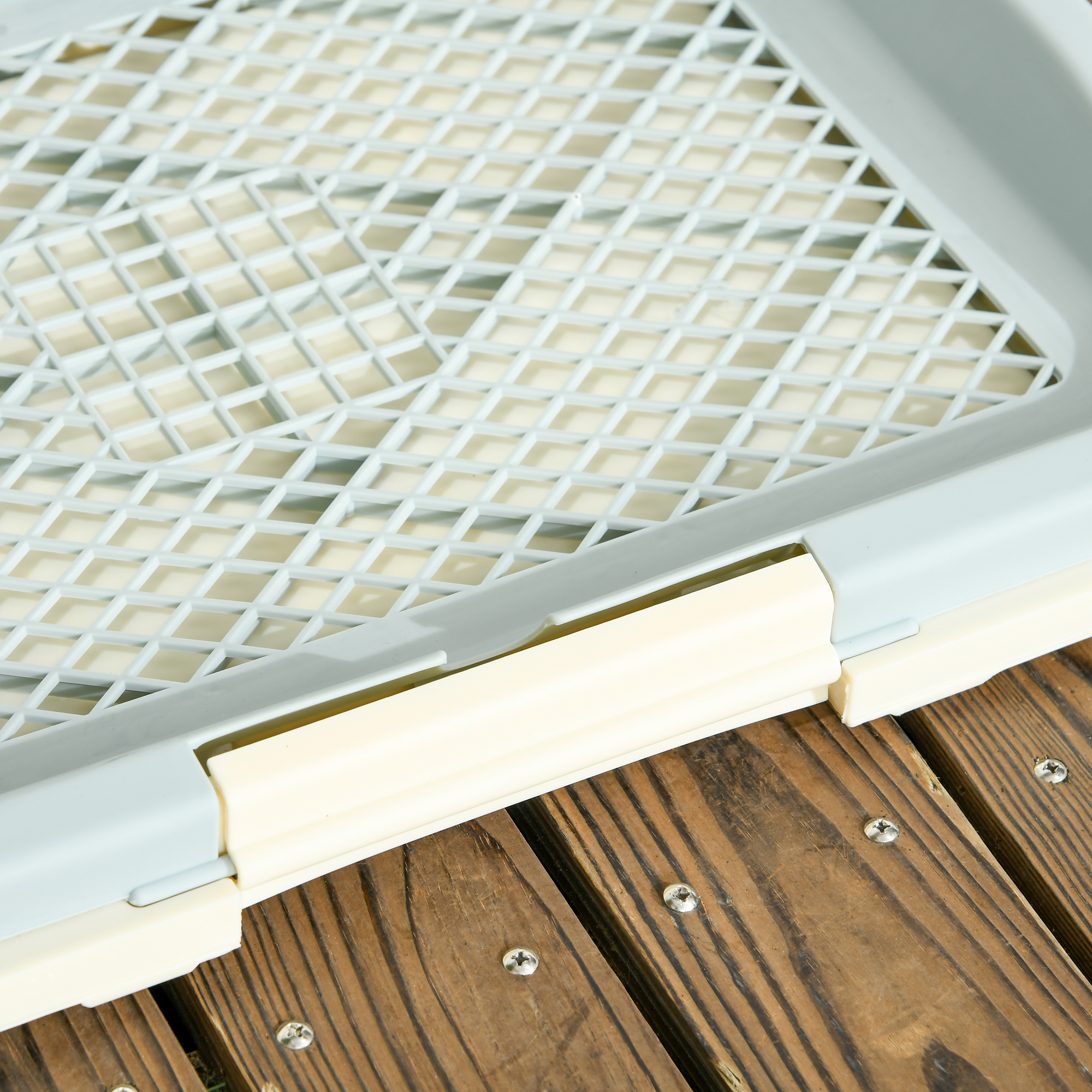 Una griglia grigia su superficie color crema su assi di legno.