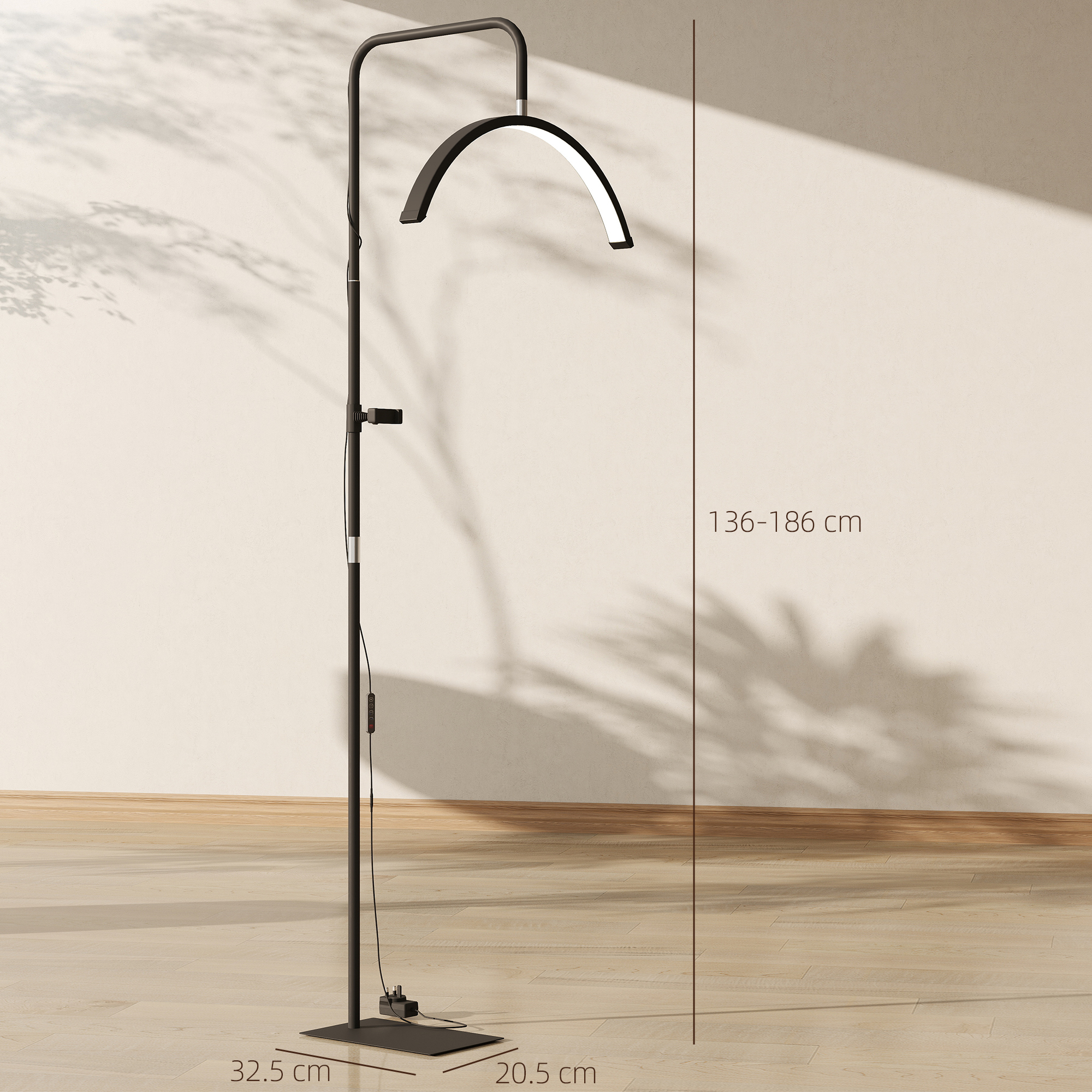 Una lampada da terra nera alta con luce curva si erge su un pavimento in legno.
