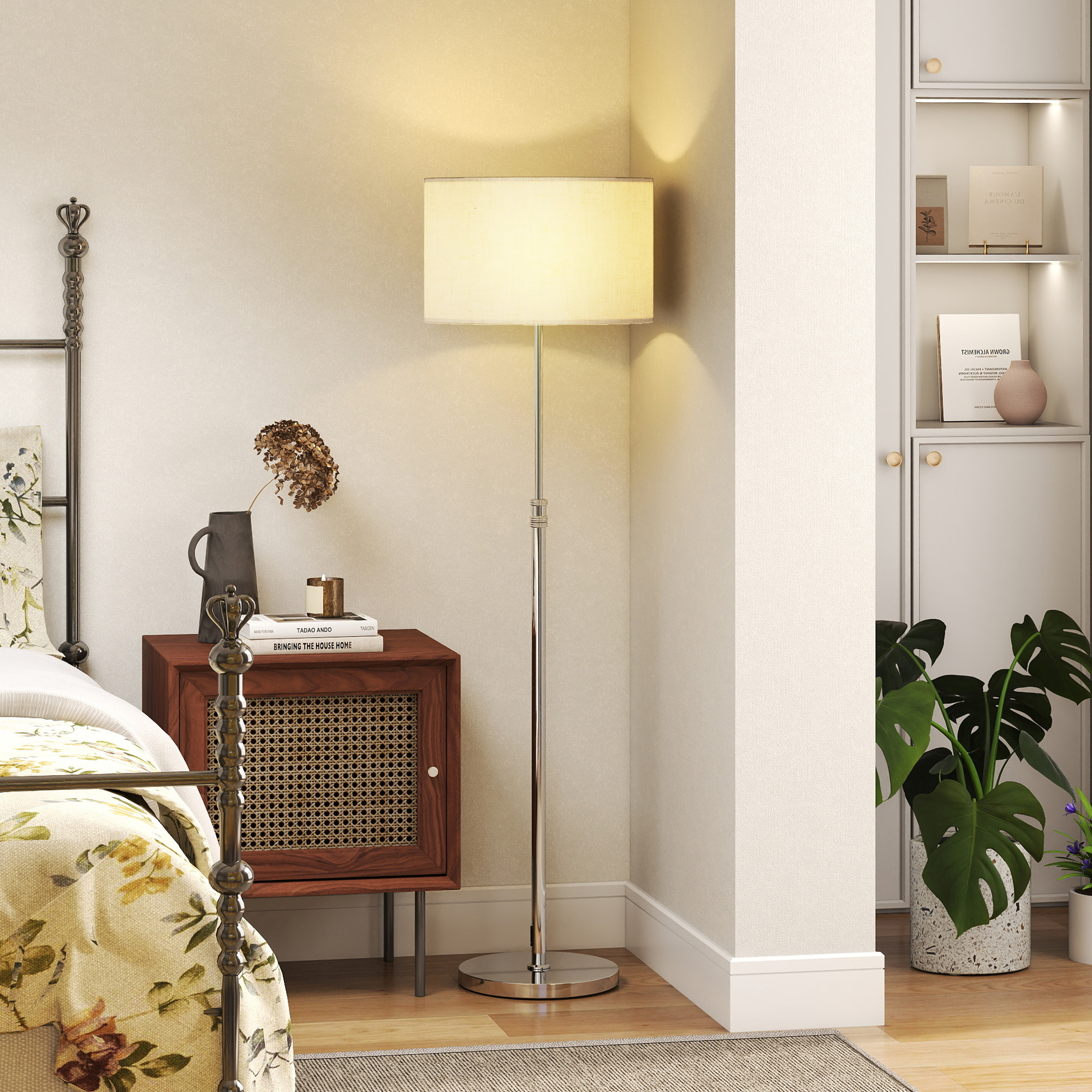 Una camera da letto con biancheria da letto floreale, comodino, lampada e piante.