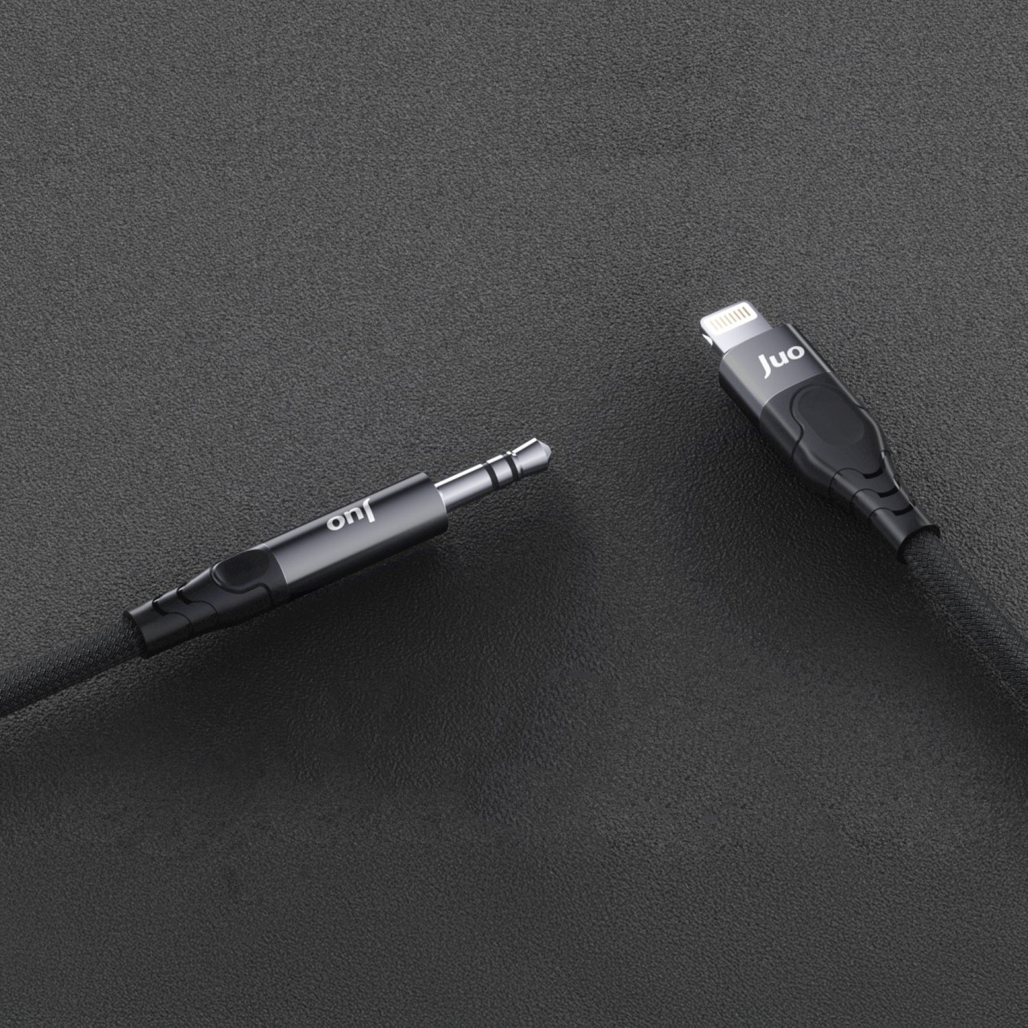 Siyah arka plan üzerinde 3,5 mm jak ve Lightning konektörlü siyah kablo.