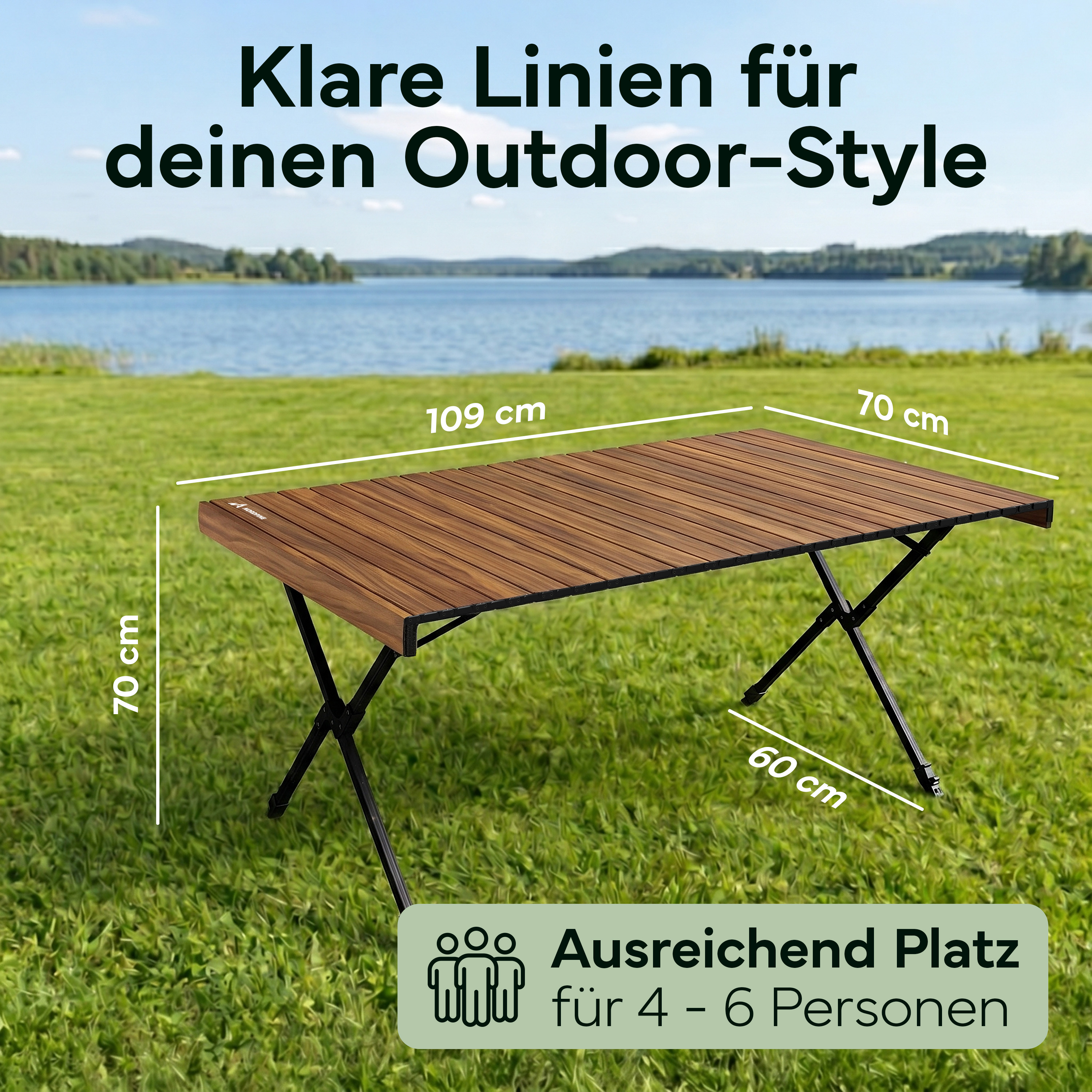 Braune Holzklapptisch mit schwarzen Beinen auf grünem Gras, See im Hintergrund.