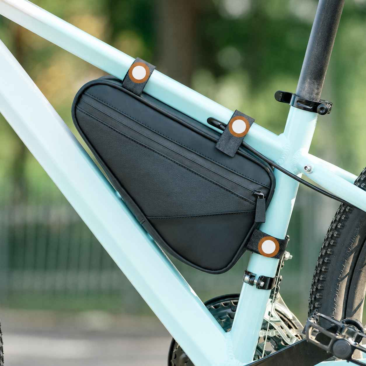 Schwarze Rahmentasche an einem hellblauen Fahrrad mit Befestigungsgurten.
