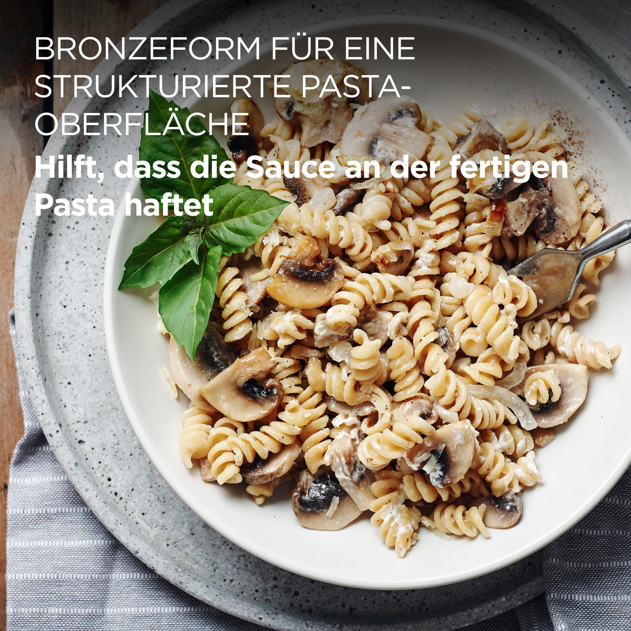 Pasta con funghi e salsa cremosa, guarnita con basilico.
