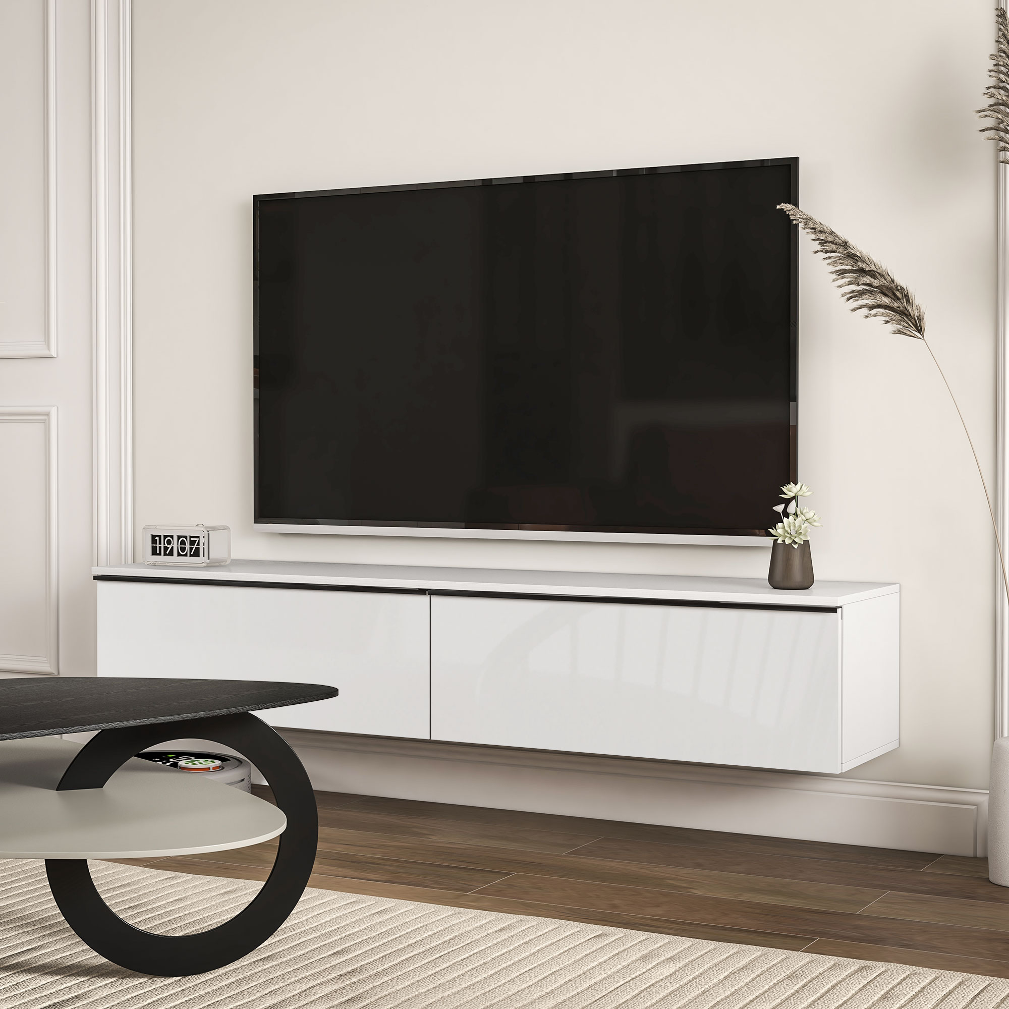 Un televisore è appeso sopra un mobile bianco con cassetti. Un tavolo è davanti.