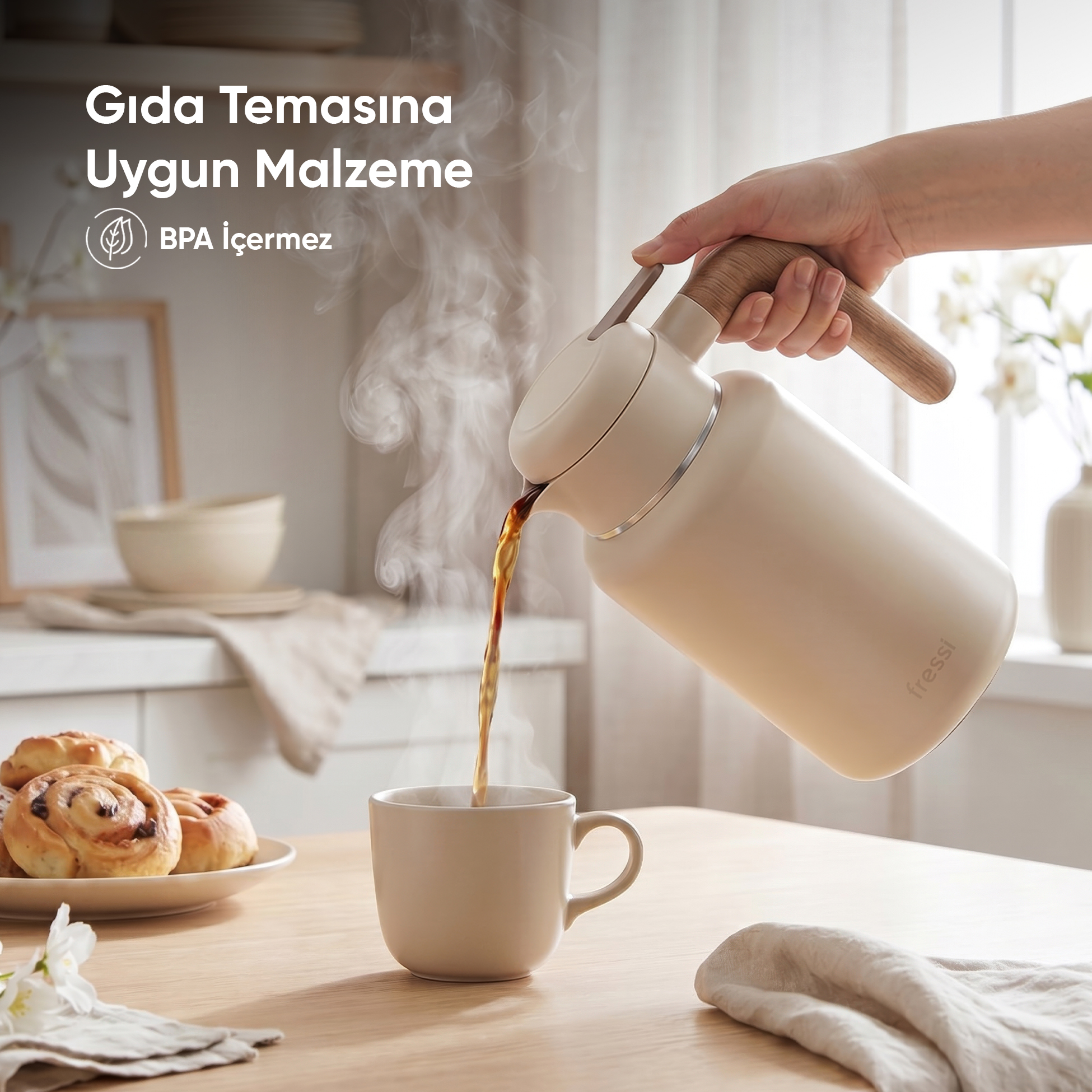 Bir el, krem renkli sürahiden fincana buğulu kahve döküyor.