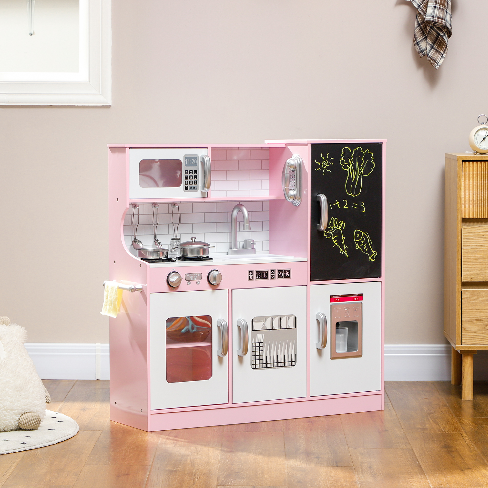 Cucina giocattolo rosa con microonde, fornelli, lavello e lavagna con disegni.
