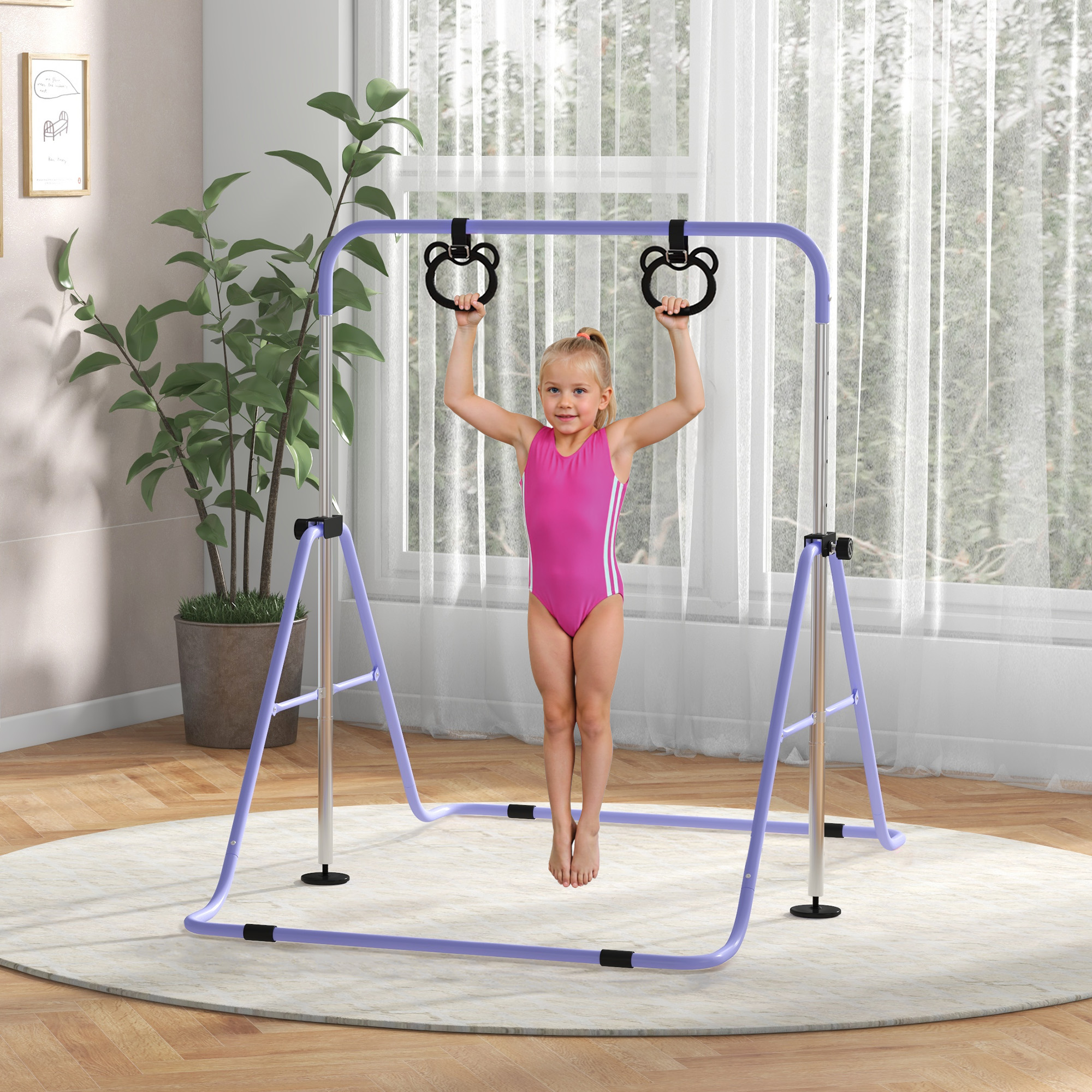 Una bambina in body rosa appesa agli anelli su una sbarra da ginnastica viola.