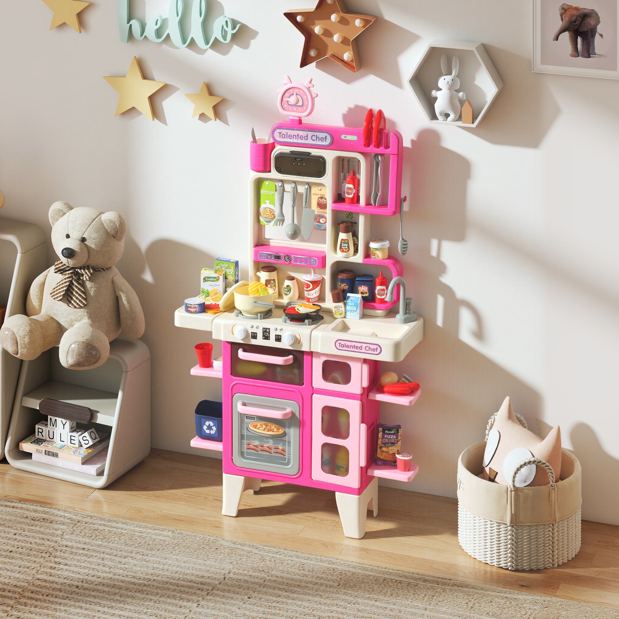 Un set da cucina giocattolo rosa con accessori, un orsacchiotto e un cesto.