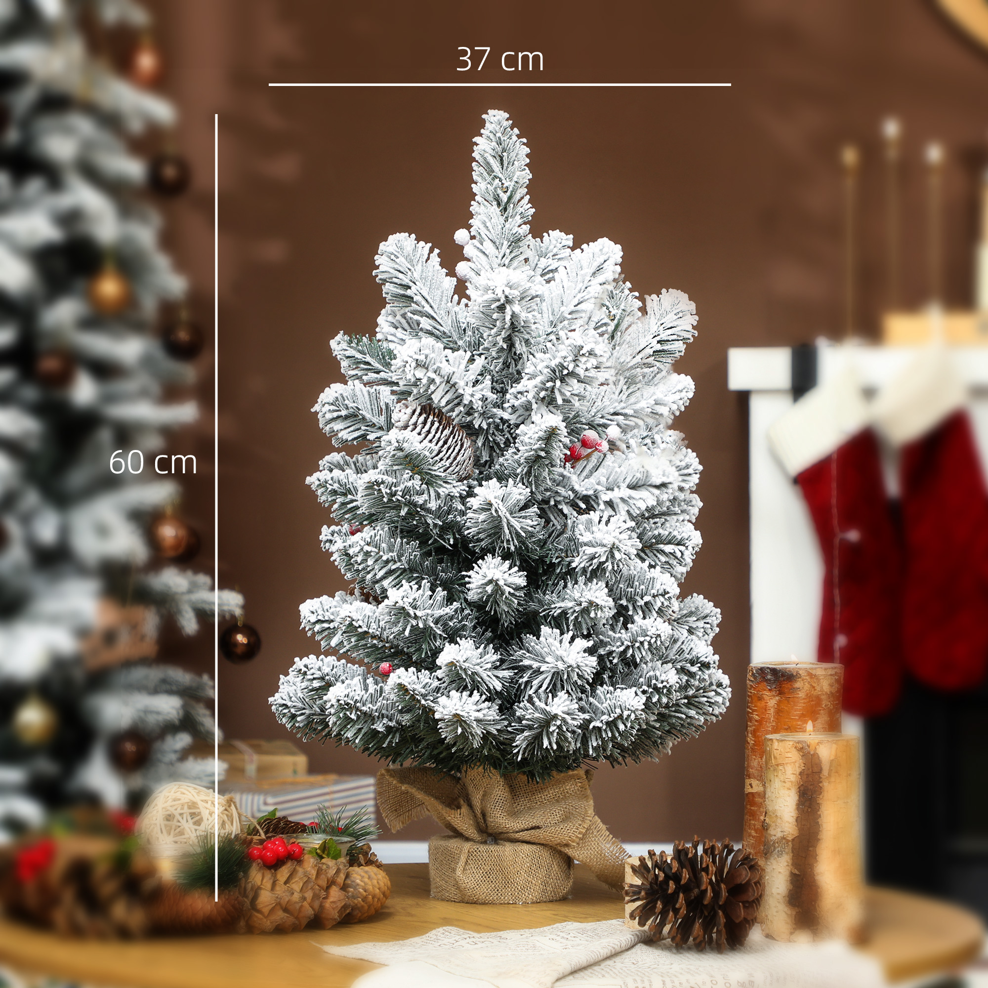 Un piccolo albero di Natale innevato, con candele e pigne sul lato.