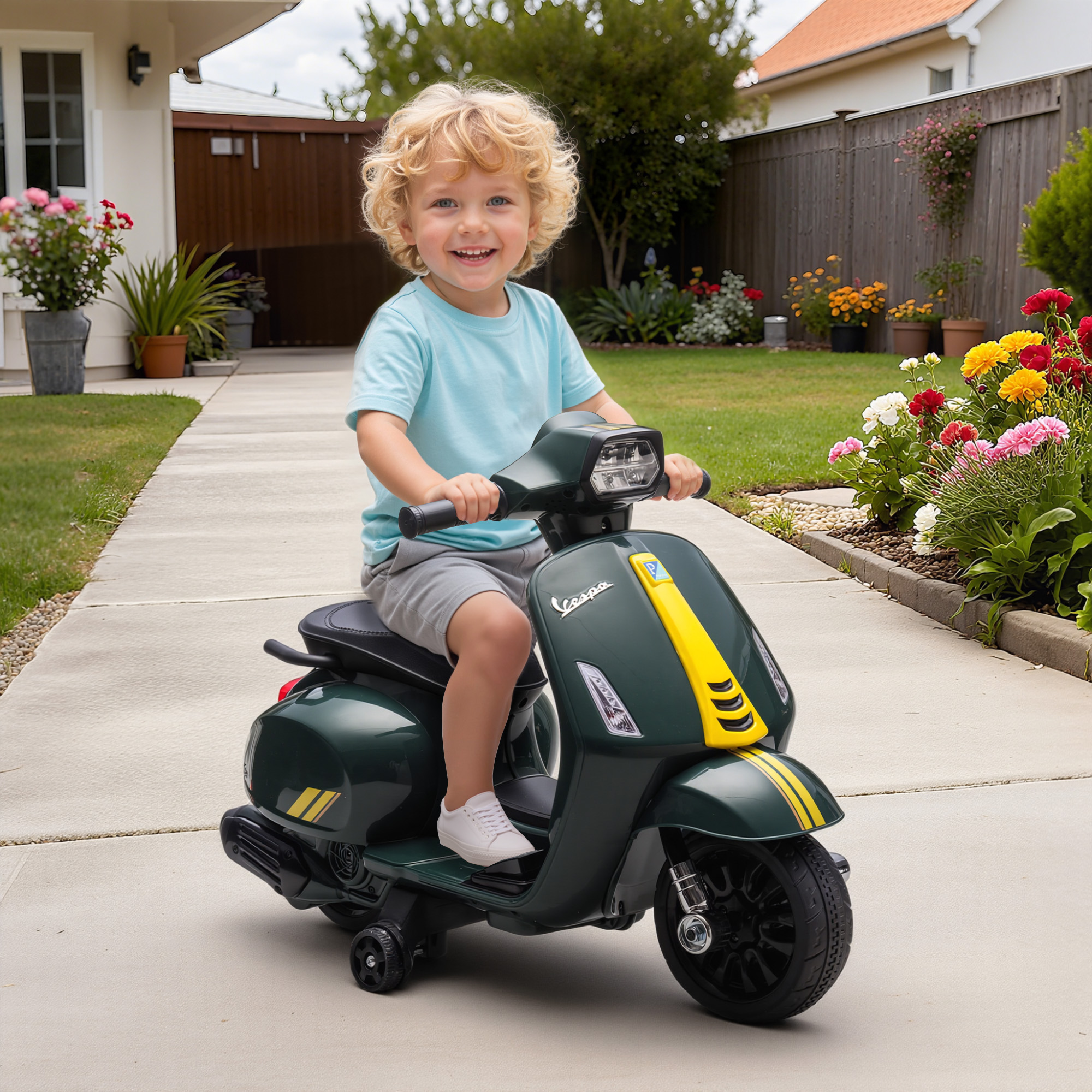 Un bambino guida uno scooter Vespa giocattolo verde scuro su un vialetto.