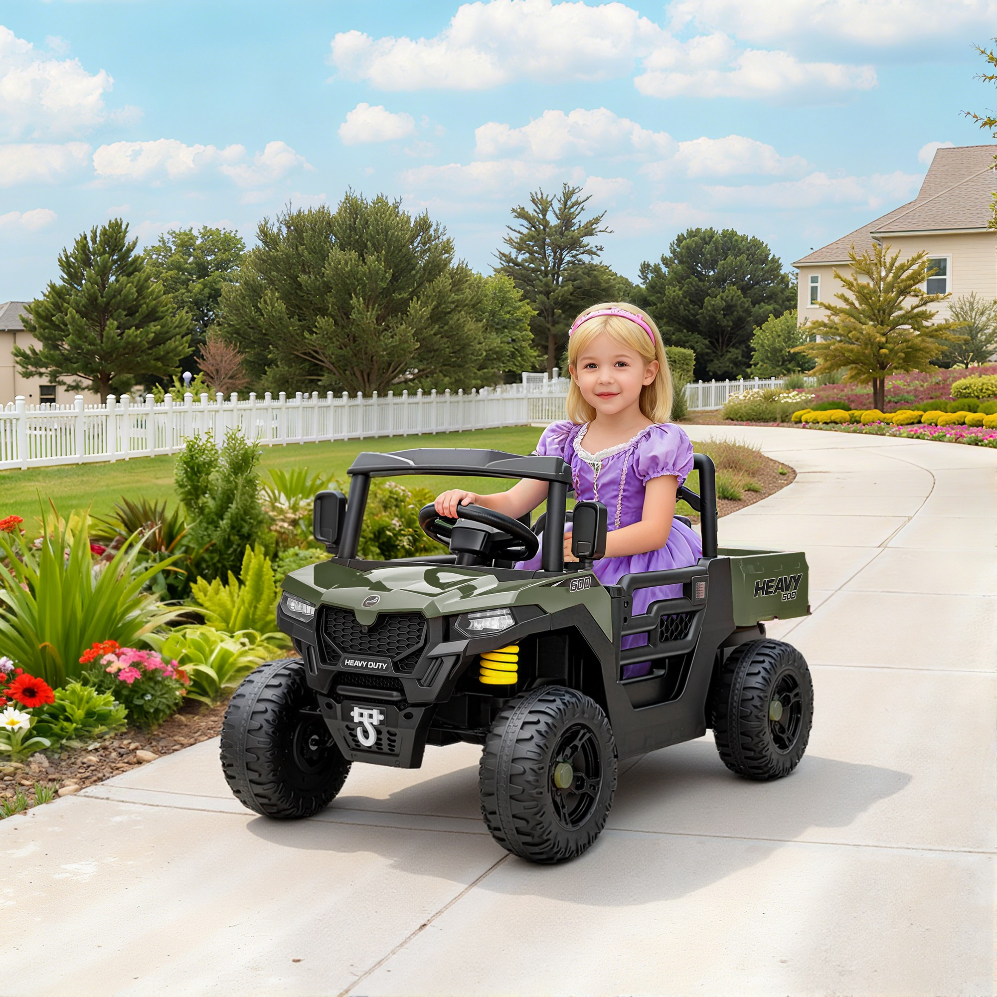 Una bambina in abito viola guida un ATV giocattolo verde su un vialetto.