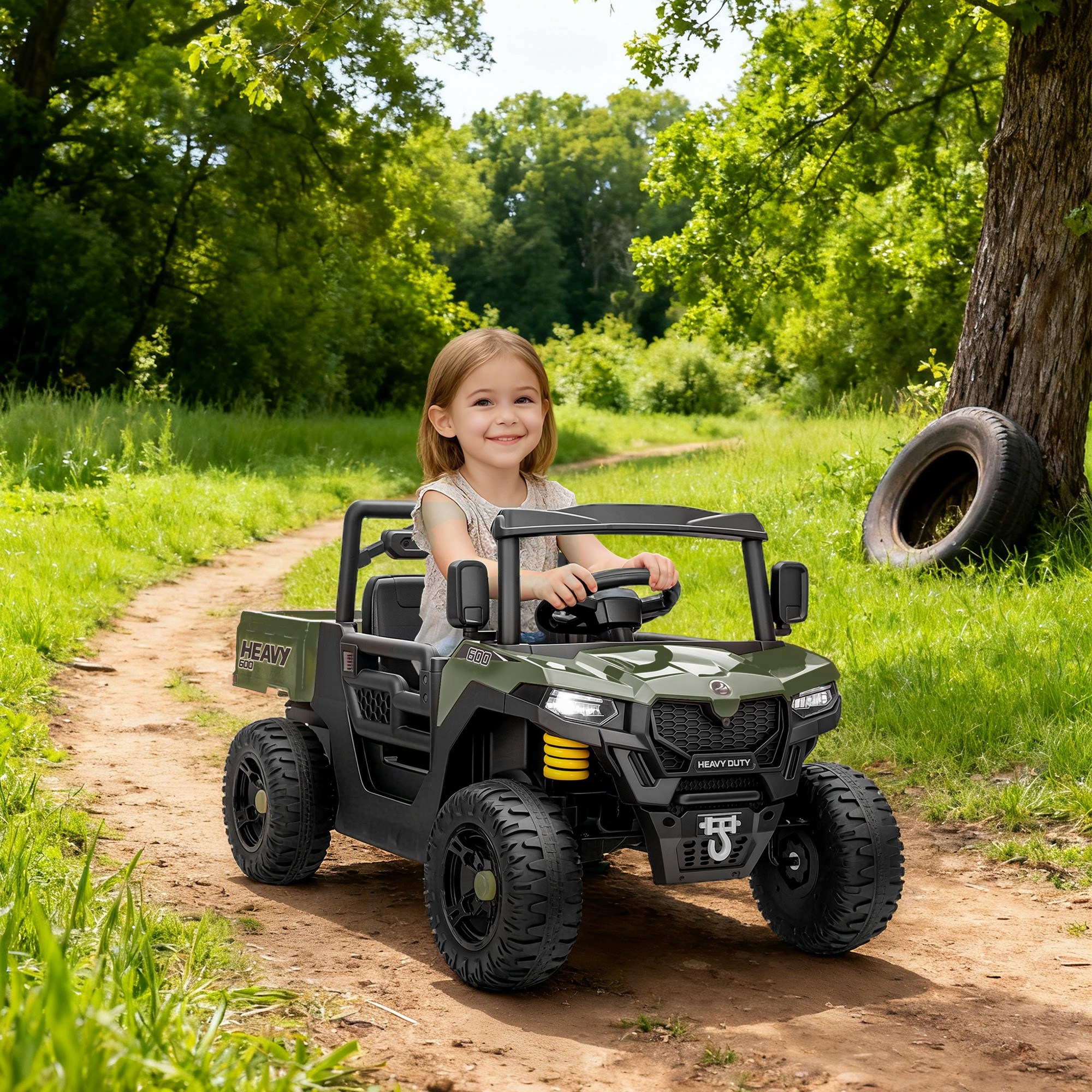 Una bambina sorridente siede su un ATV giocattolo verde su un sentiero sterrato.