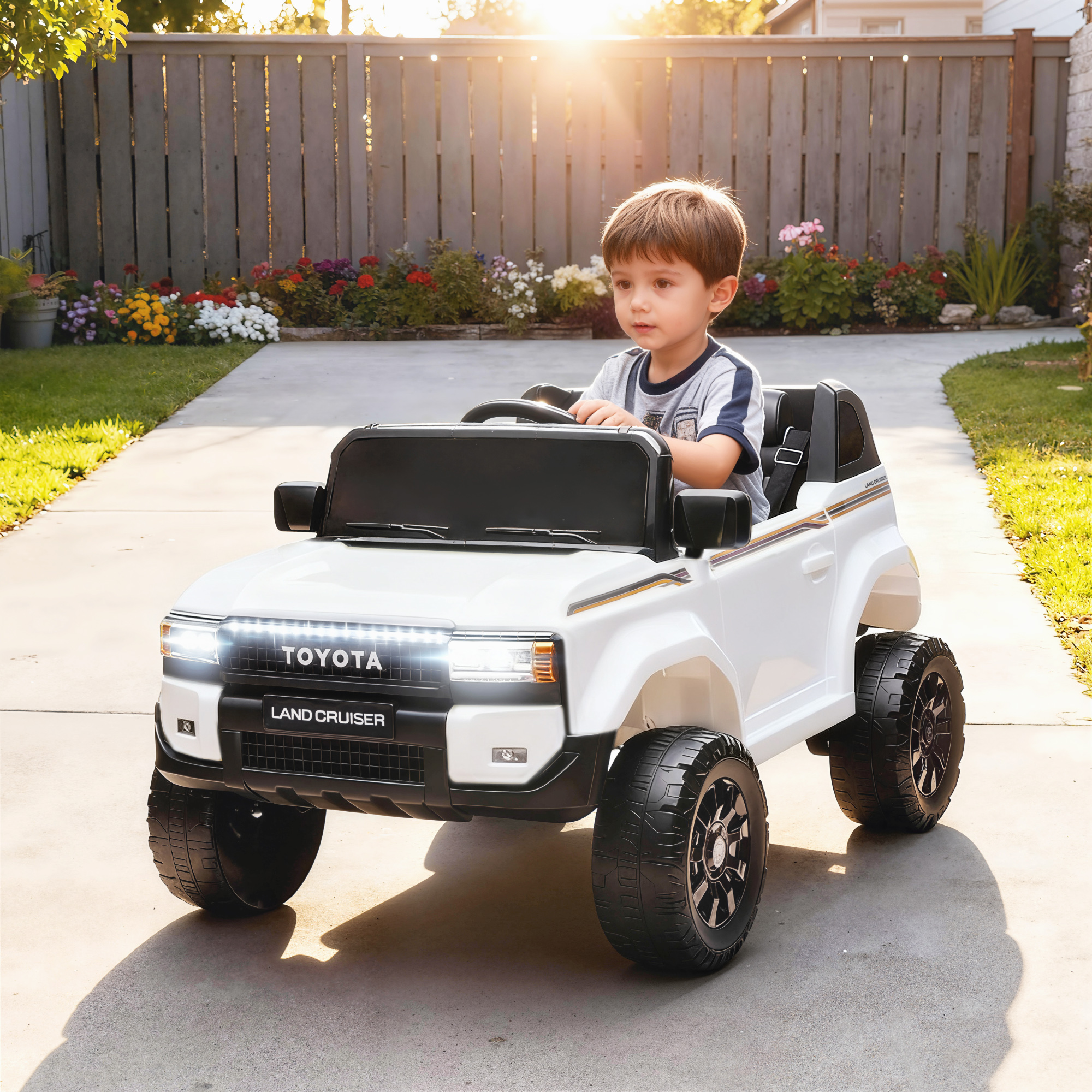 Un bambino guida un'auto giocattolo bianca Toyota Land Cruiser in un cortile.