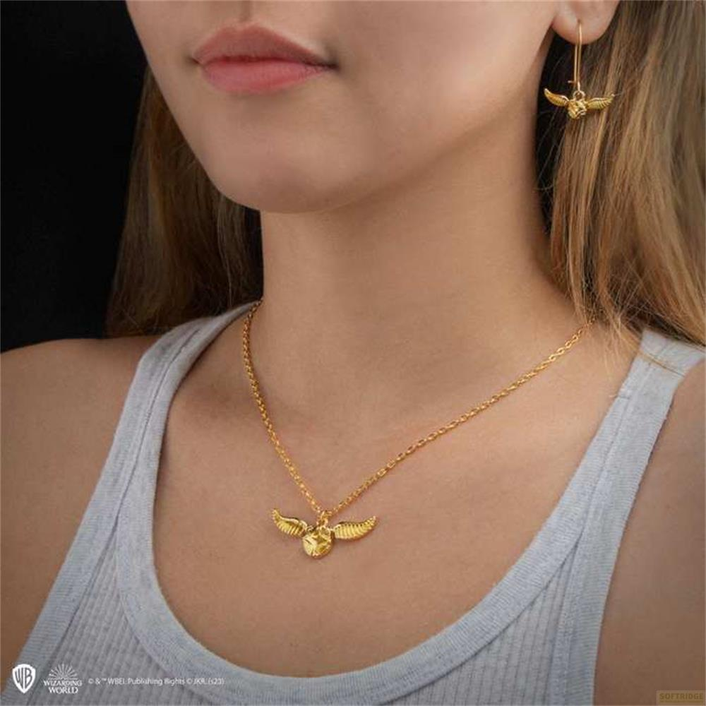 Collana d'oro con ciondolo dorato e orecchino abbinato indossati da una modella.