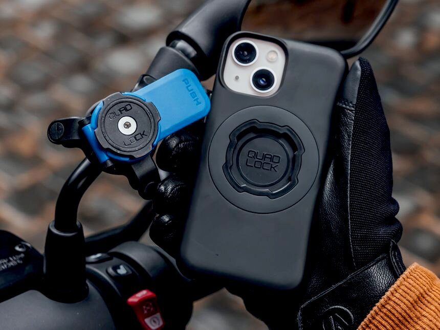 Ein schwarzes Smartphone mit Quad Lock Halterung an einem blauen Fahrrad-Lenkerhalter.