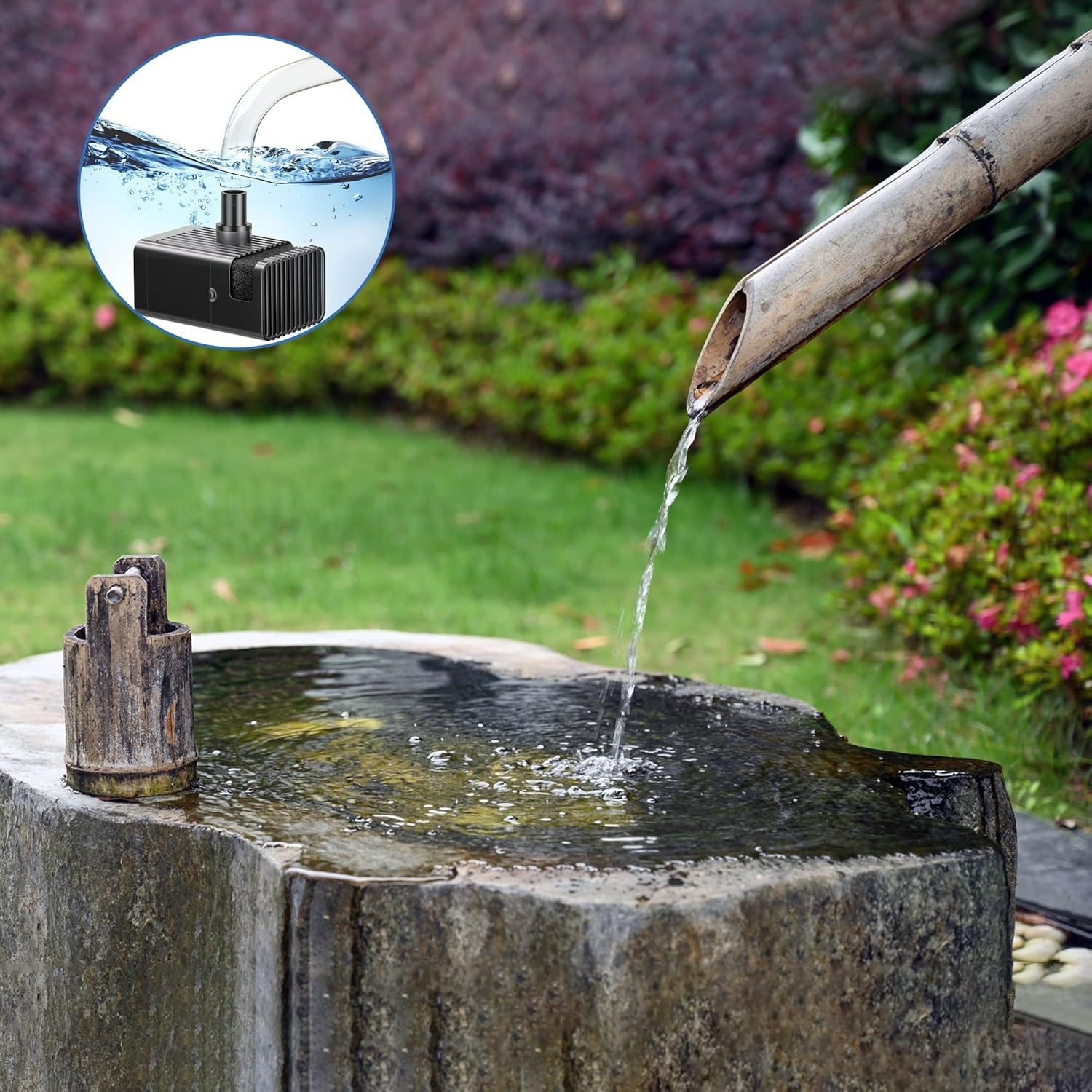 Eine kleine schwarze Wasserpumpe unter Wasser, mit einem Bambusrohr, das Wasser in ein Steinbecken leitet.