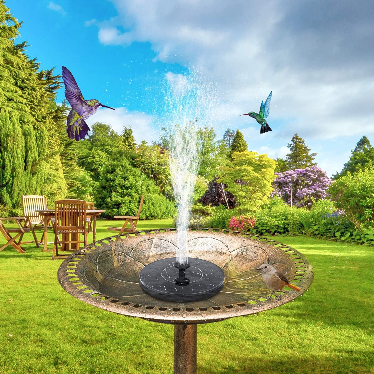 Ein Vogelbad mit einem Solarbrunnen und zwei Kolibris, die im Garten fliegen.