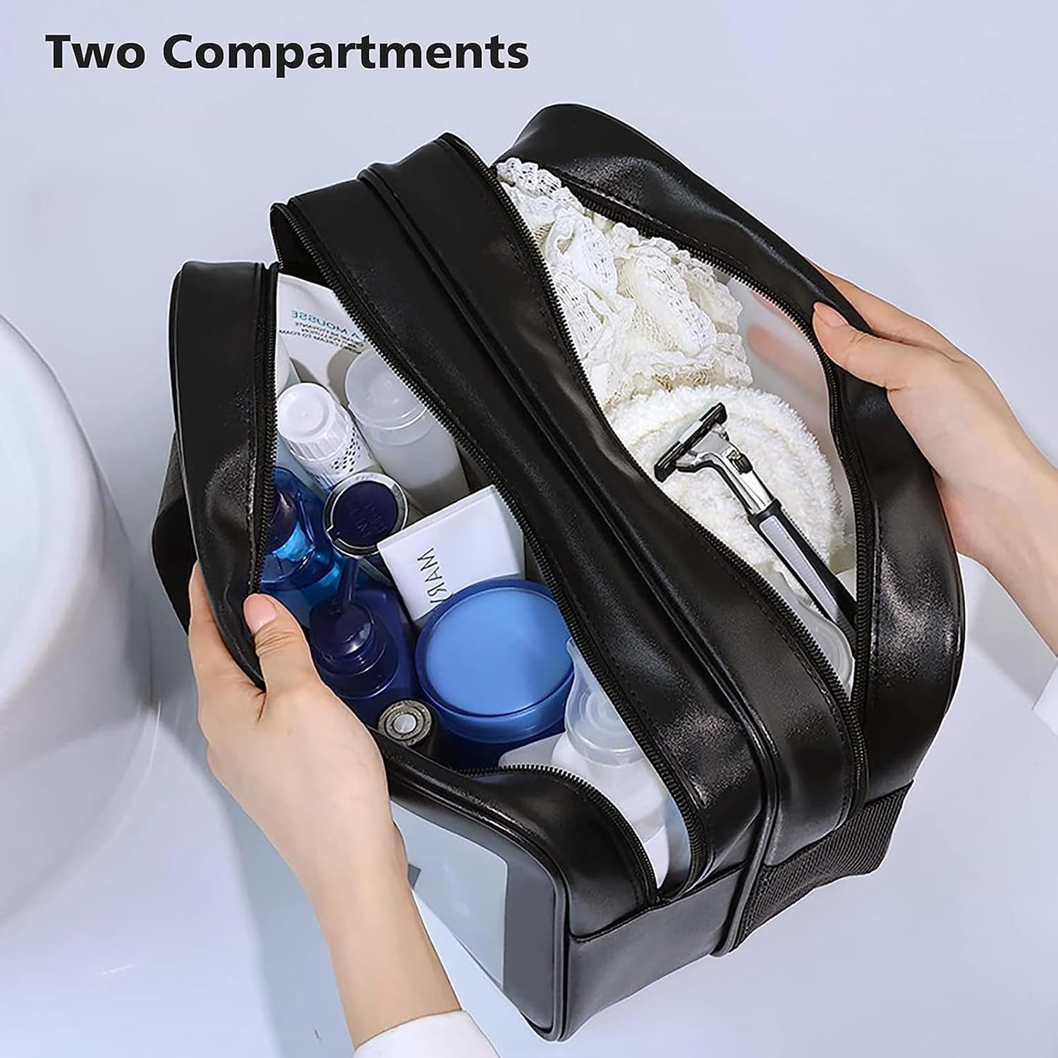 Schwarze Kulturtasche mit zwei Fächern, gefüllt mit Toilettenartikeln, Rasierer und Handtuch.