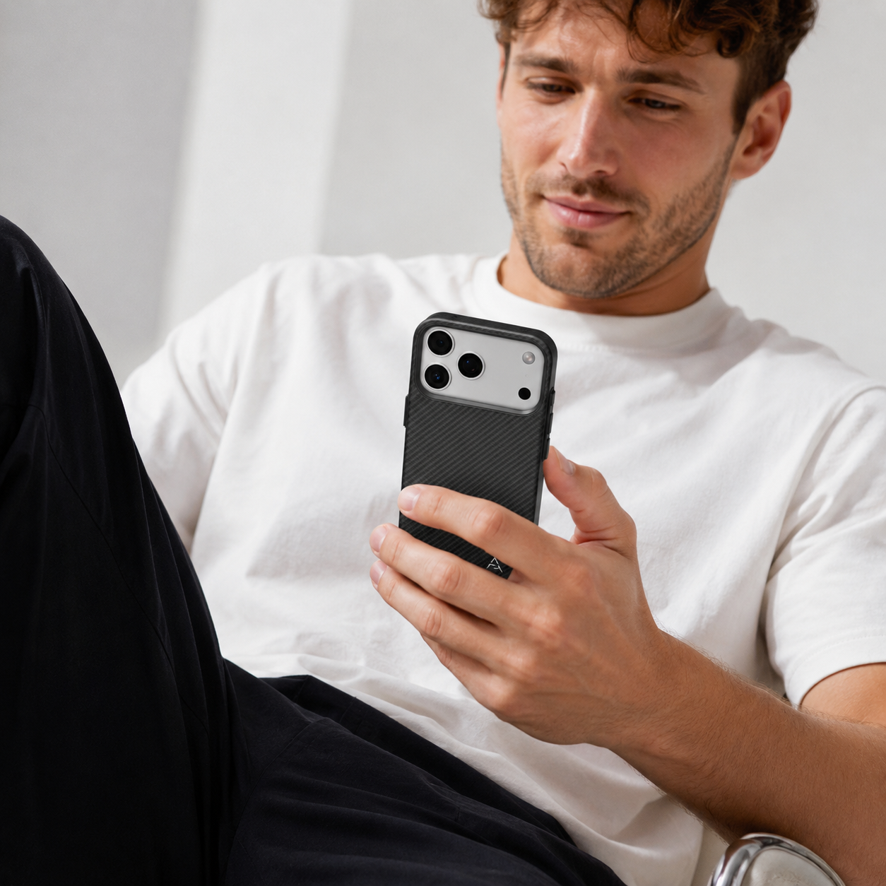 Un hombre sosteniendo y mirando un smartphone.