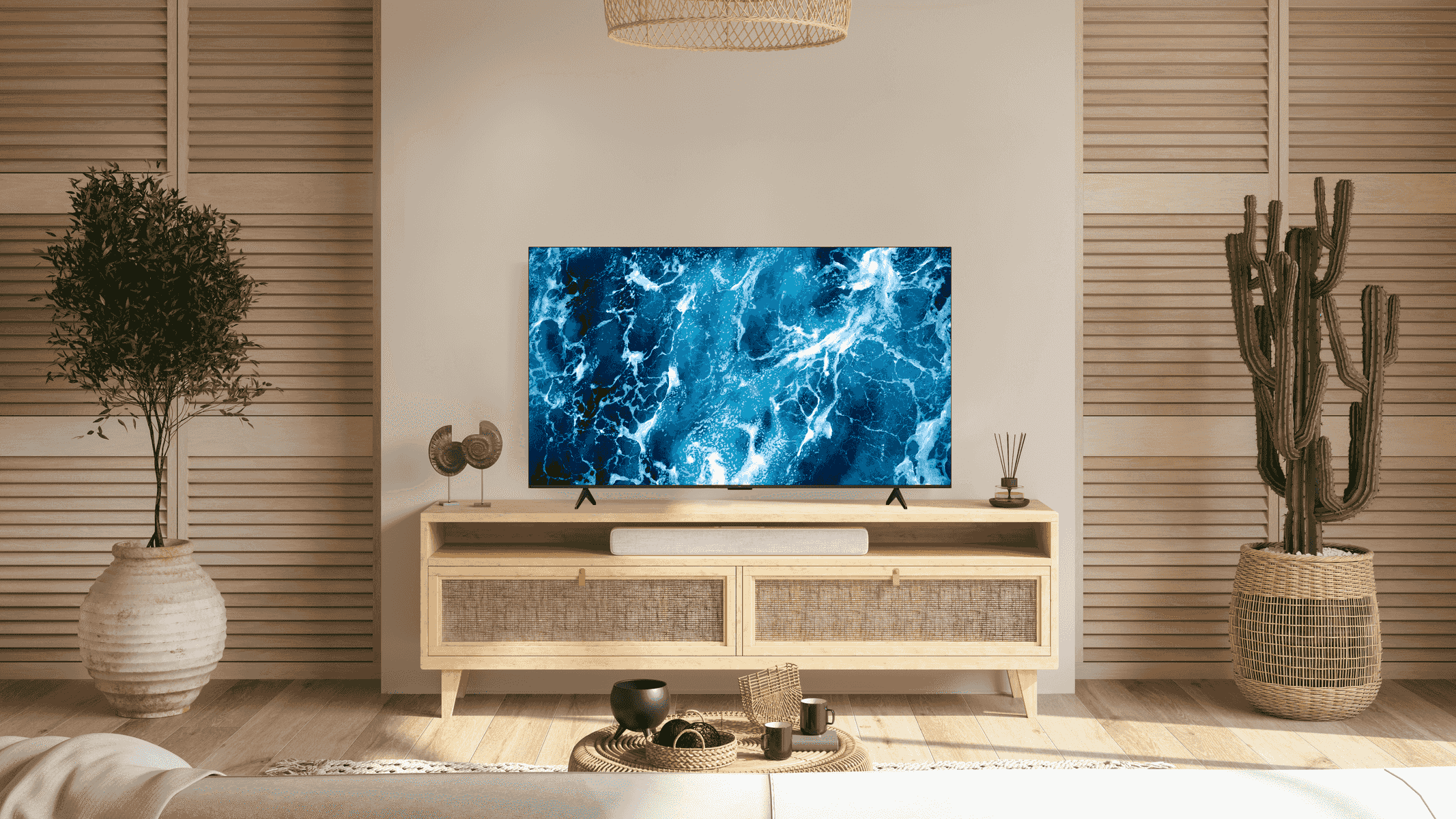 Salon z telewizorem pokazującym niebieską scenę oceanu. Po prawej stronie stoi kaktus.