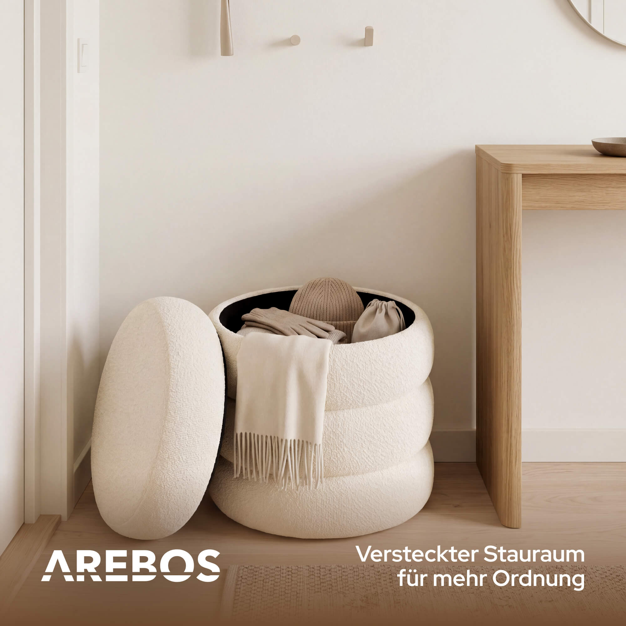 Ein runder, weißer Hocker mit Decke, Mütze und Handschuhen.