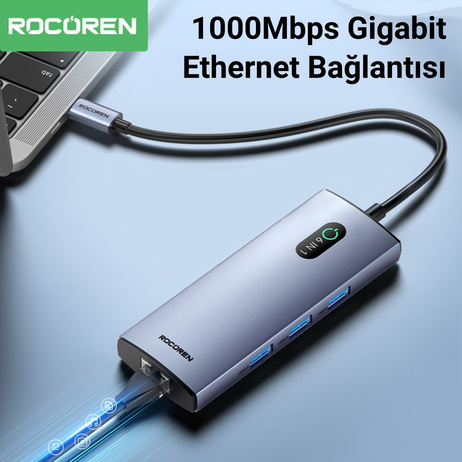 Ethernet portlu gri USB-C hub, bir dizüstü bilgisayara bağlı.