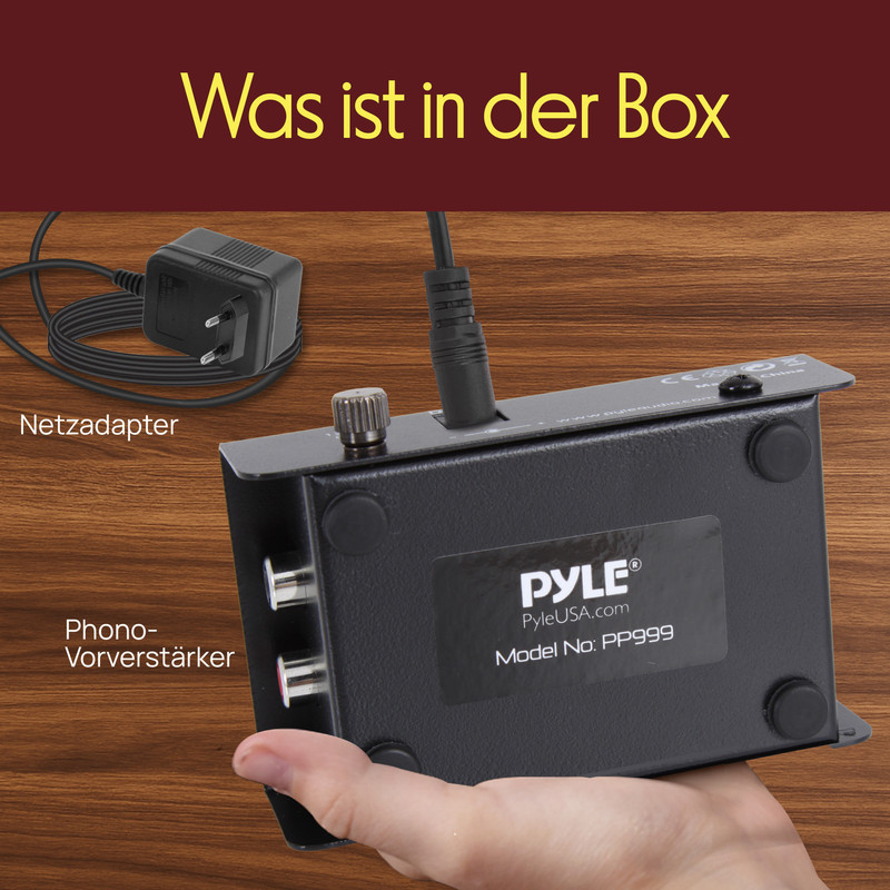 Ein Netzadapter und ein Phono-Vorverstärker von Pyle liegen auf Holz.