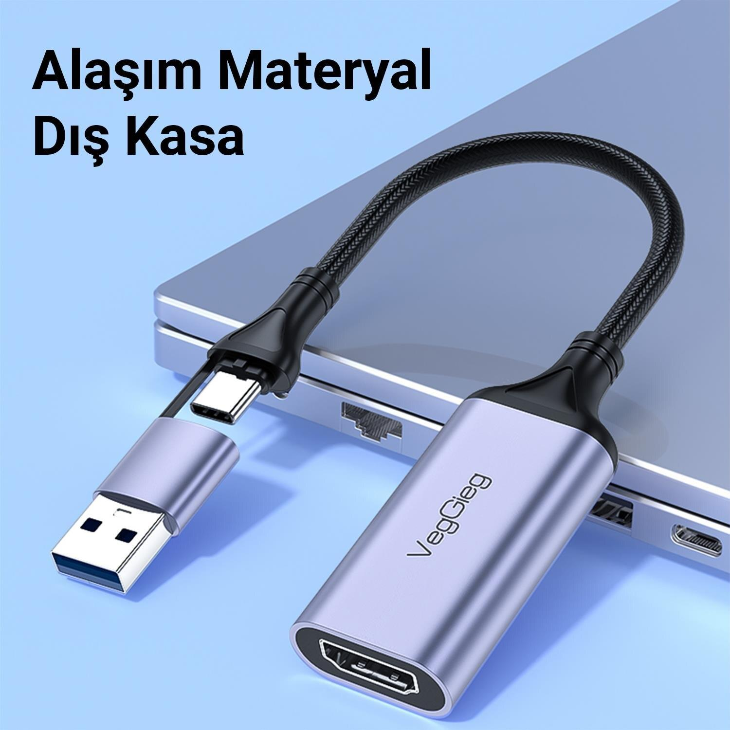 Gümüş USB-C - HDMI adaptörü, USB-A bağlantı noktası ile dizüstü bilgisayarın üzerinde duruyor.