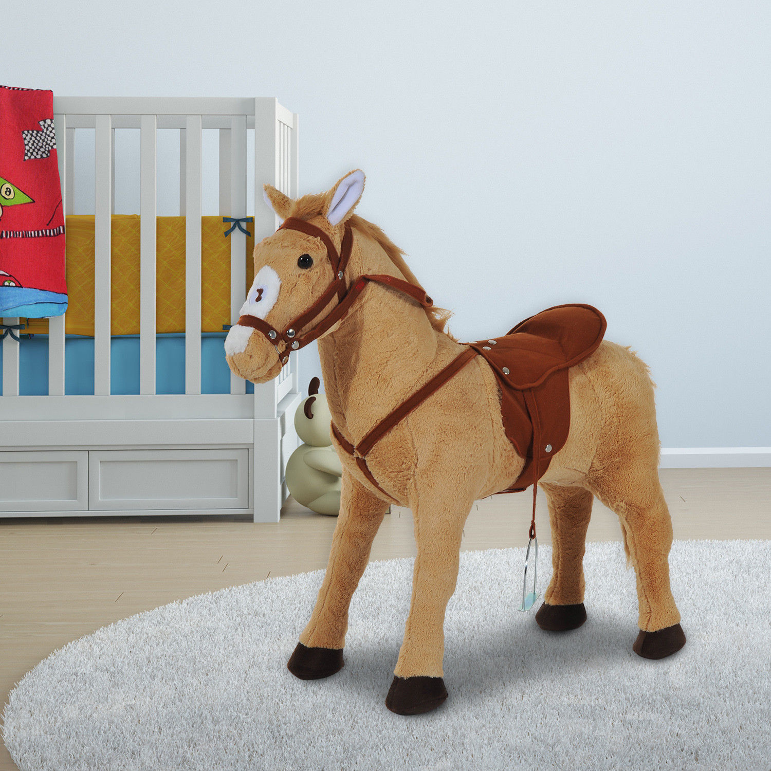 Un cavallo di peluche marrone con sella si trova su un tappeto accanto a una culla.