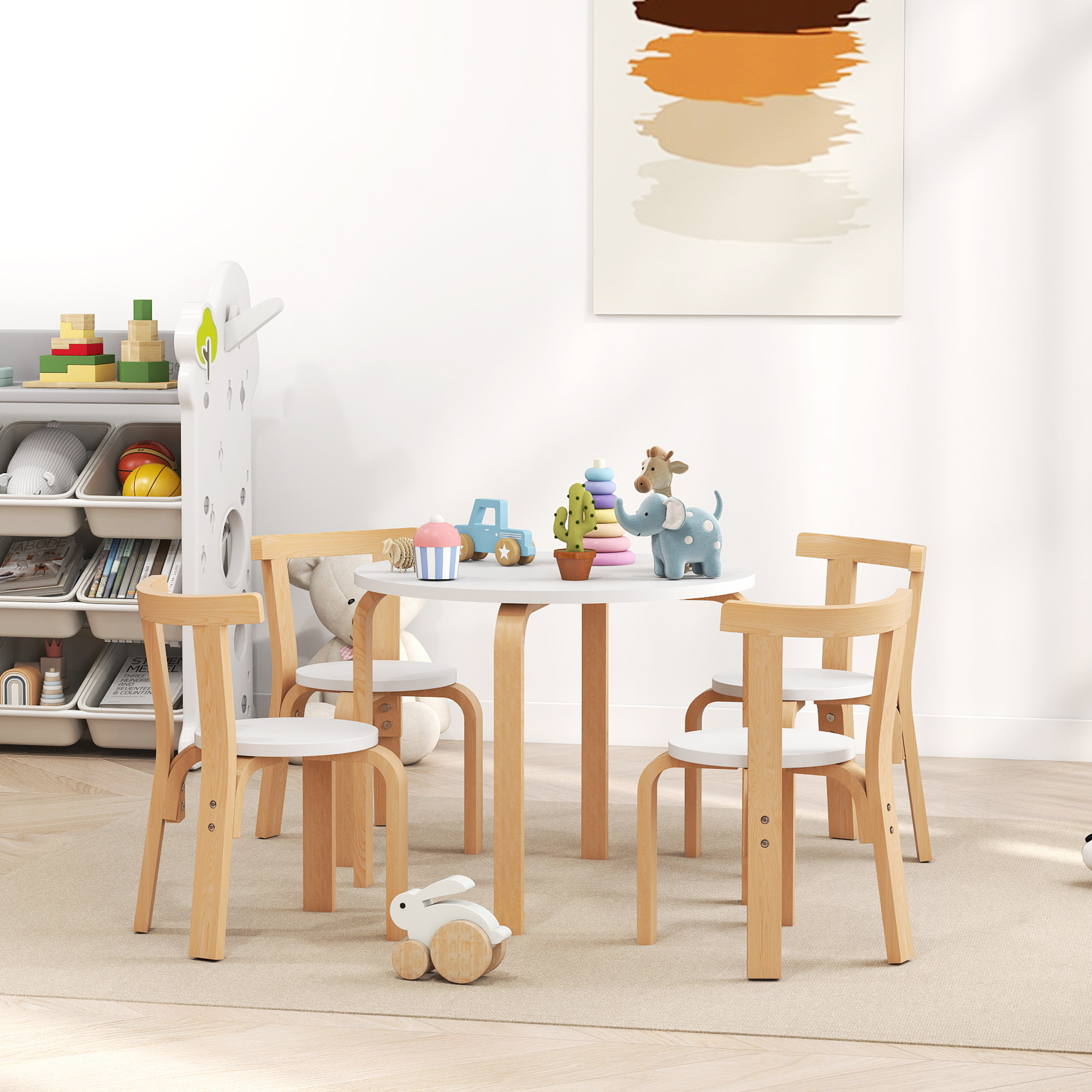 Tavolo per bambini con quattro sedie, giocattoli e un quadro al muro.