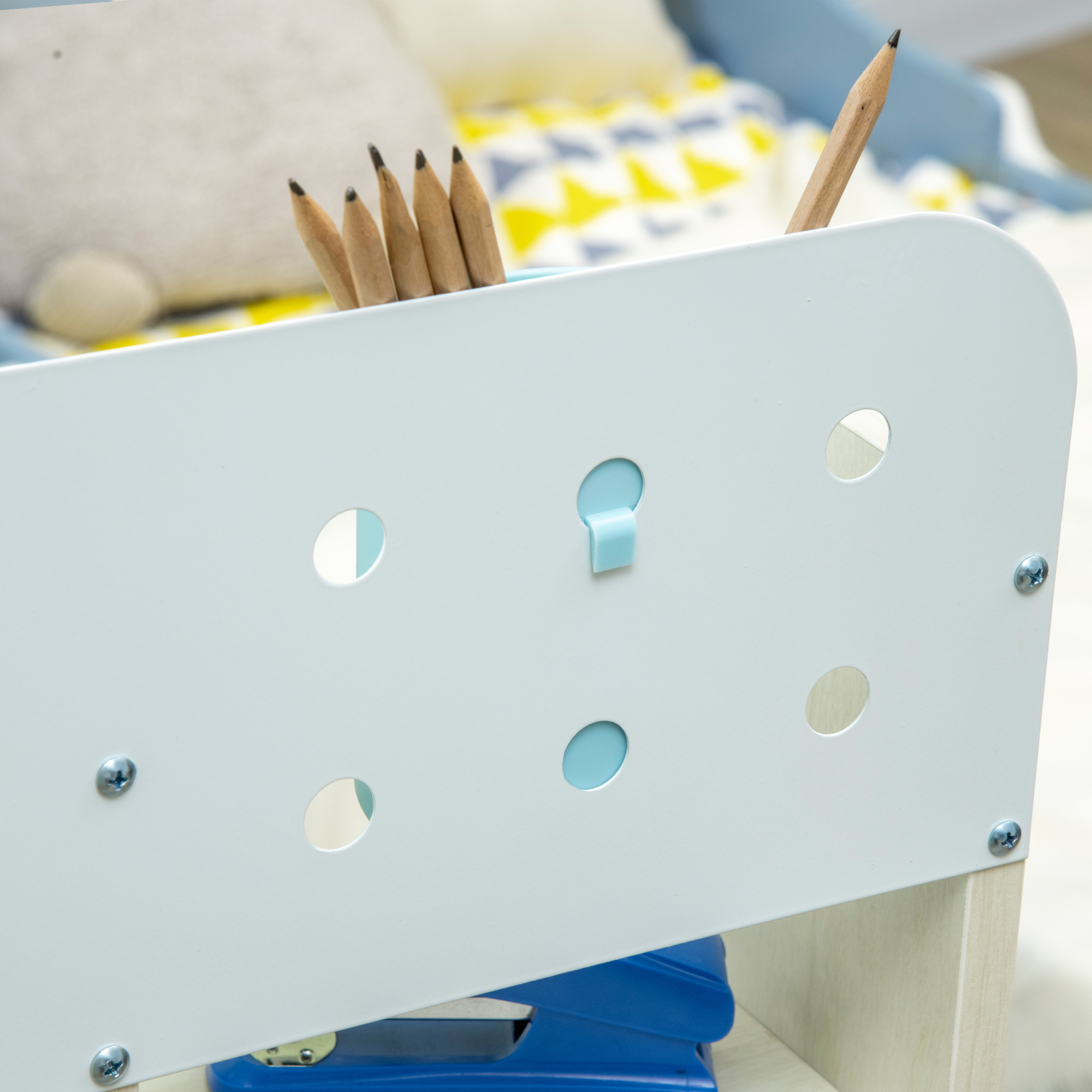 Matite in un contenitore bianco davanti a biancheria da letto fantasia.