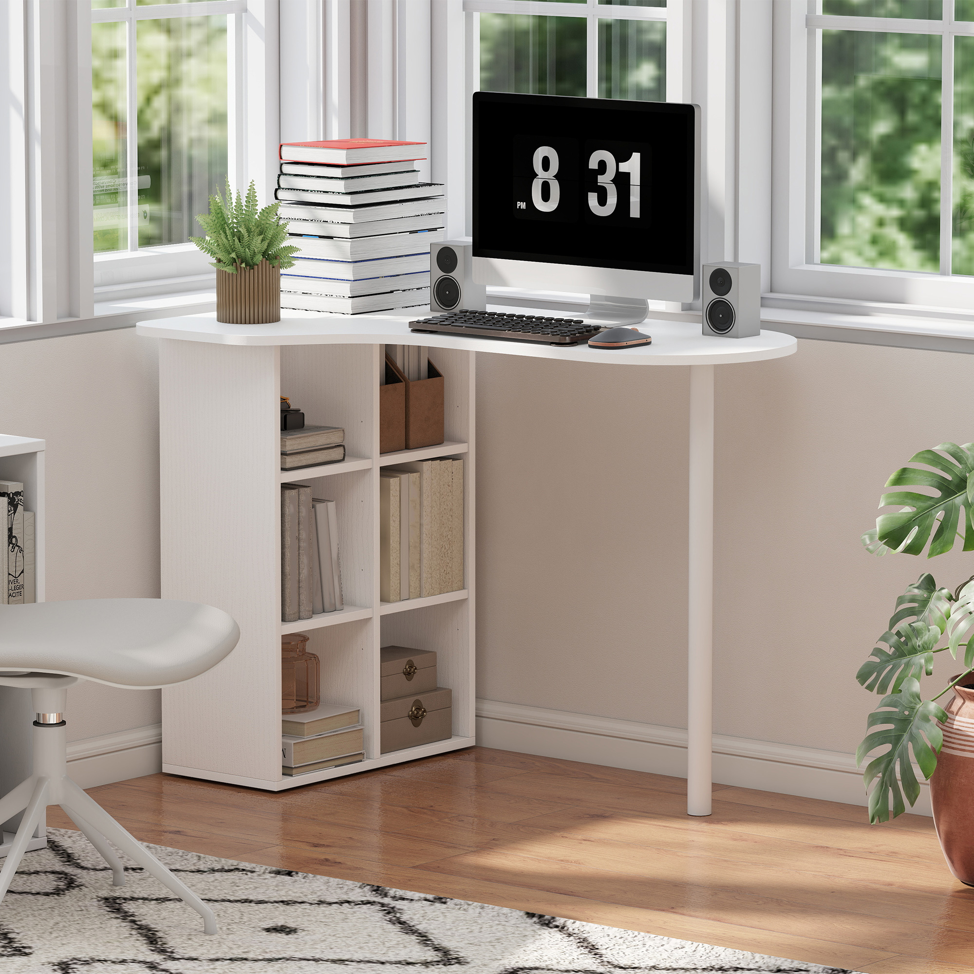 Scrivania con computer, libri, pianta e sedia vicino alla finestra.