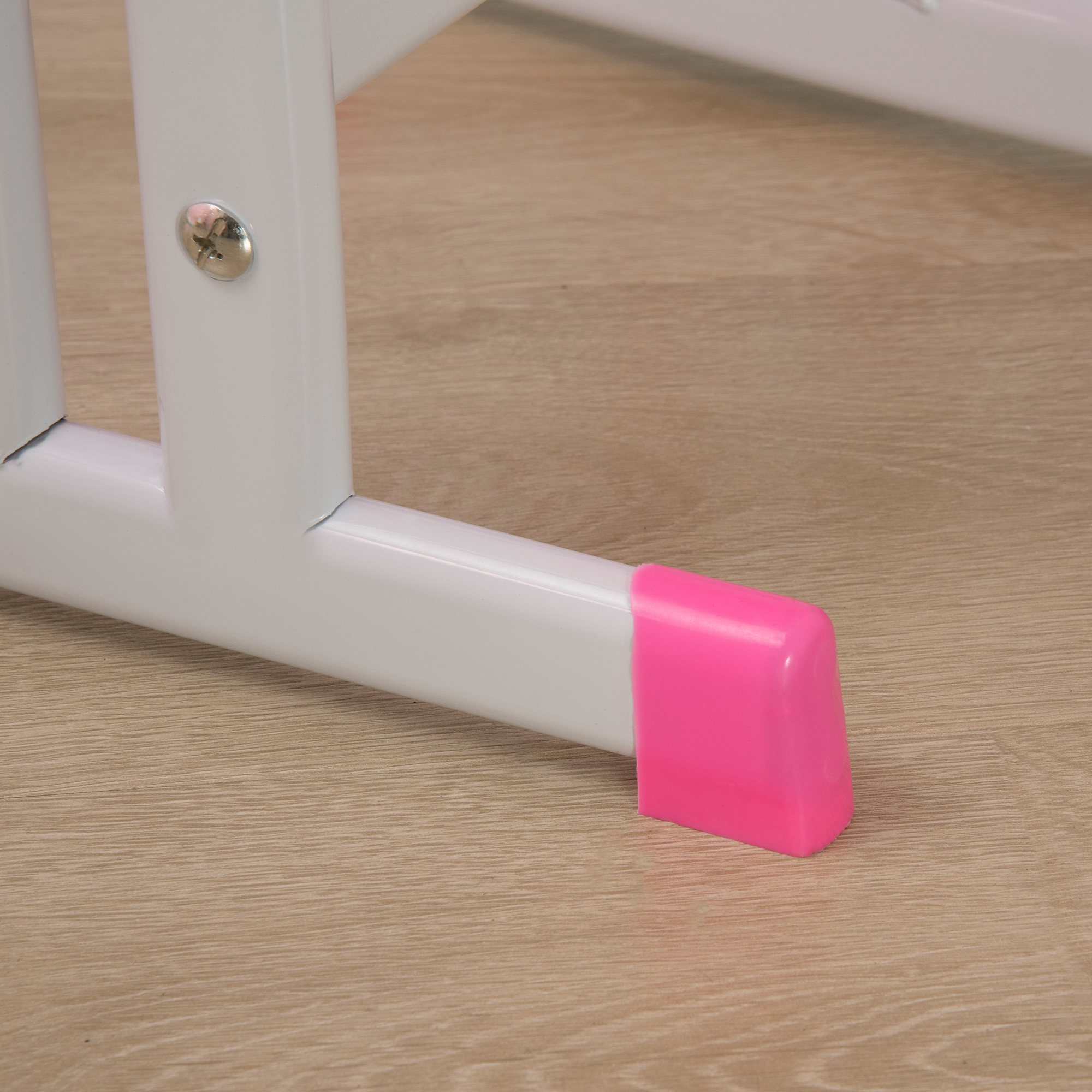 Una struttura metallica bianca con un tappo di gomma rosa sul pavimento.