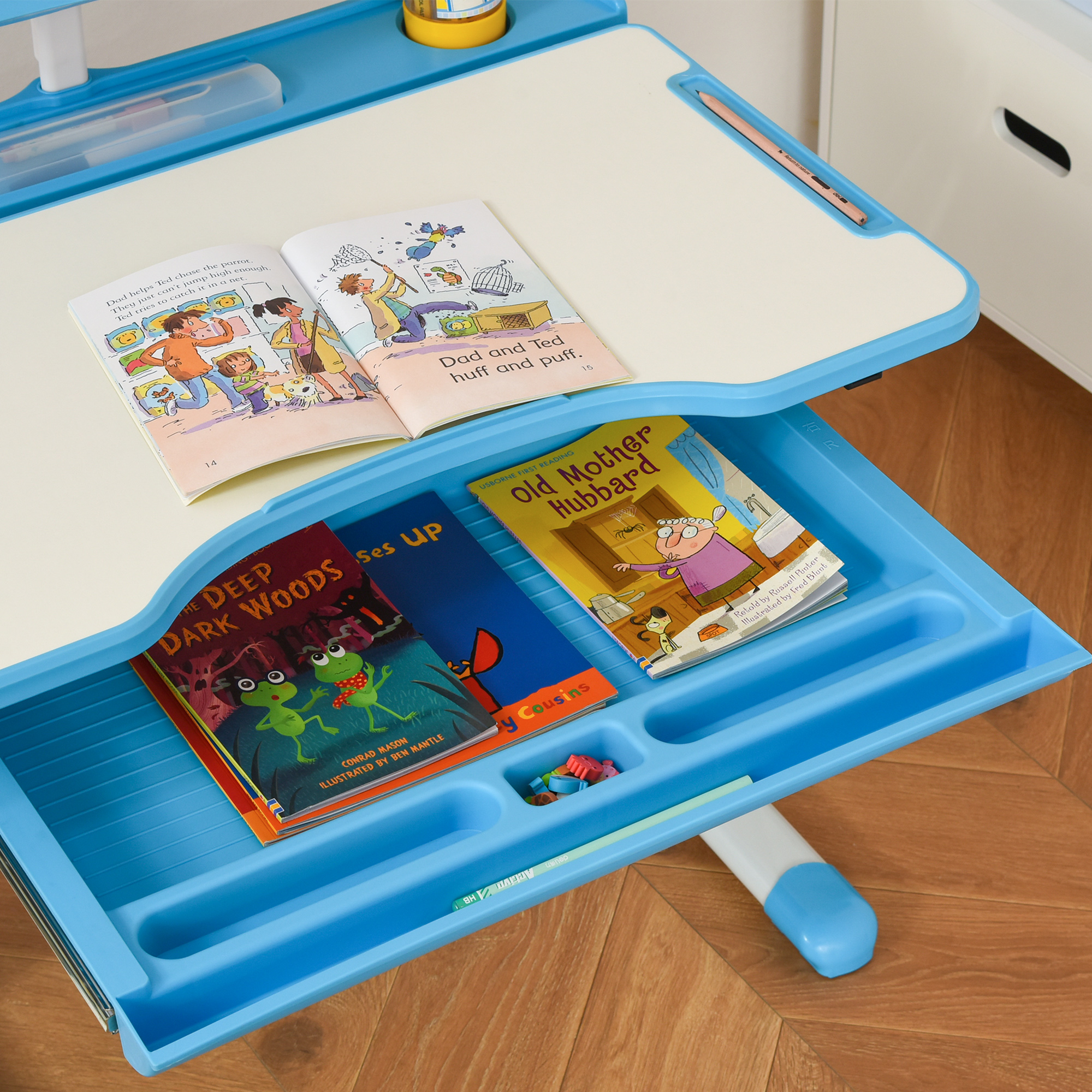 Una scrivania blu con libri aperti e scomparti per matite.