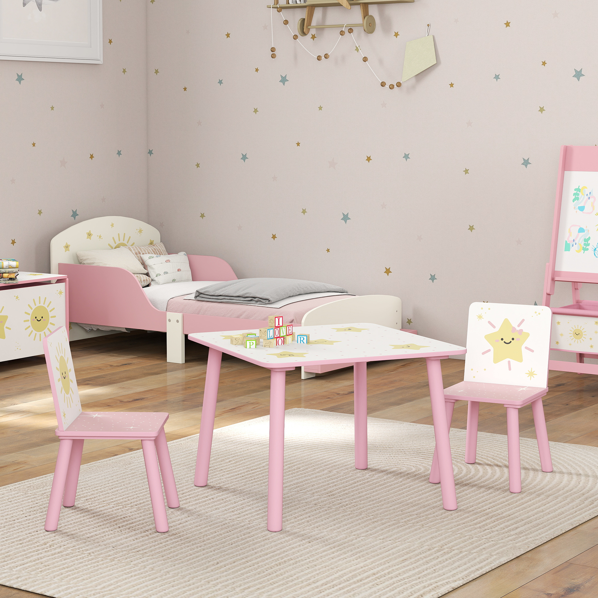 Stanza per bambini con letto, tavolo e due sedie rosa a tema stelle.