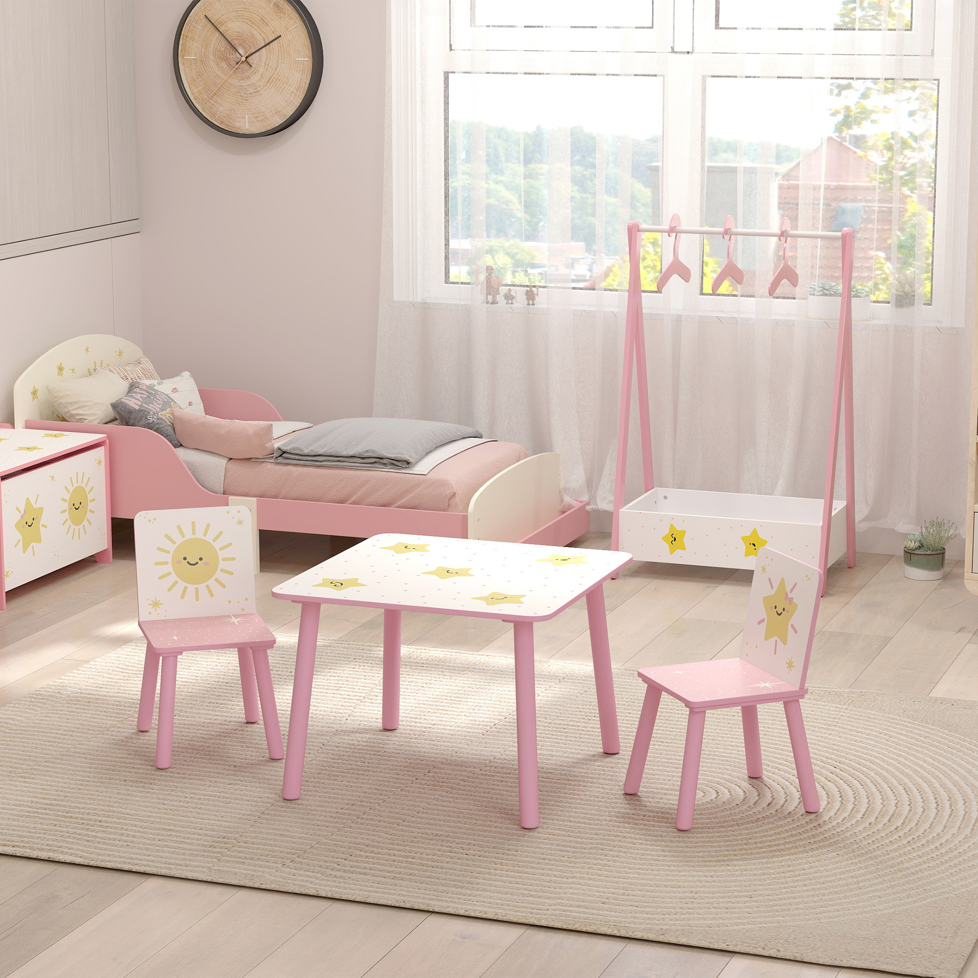 Stanza per bambini con letto, tavolo e sedie rosa a motivi di stelle.