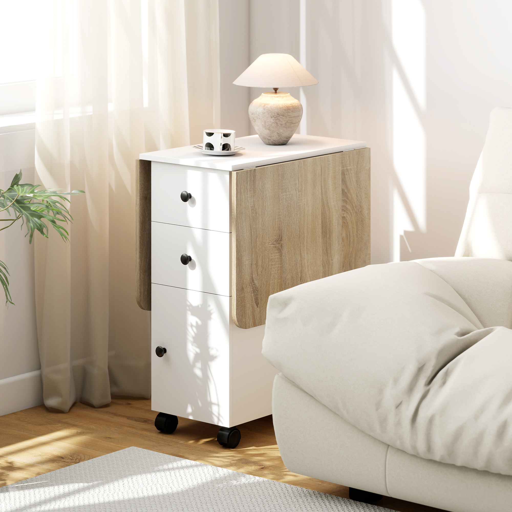 Un comodino bianco con anta a ribalta in legno, lampada e tazza.