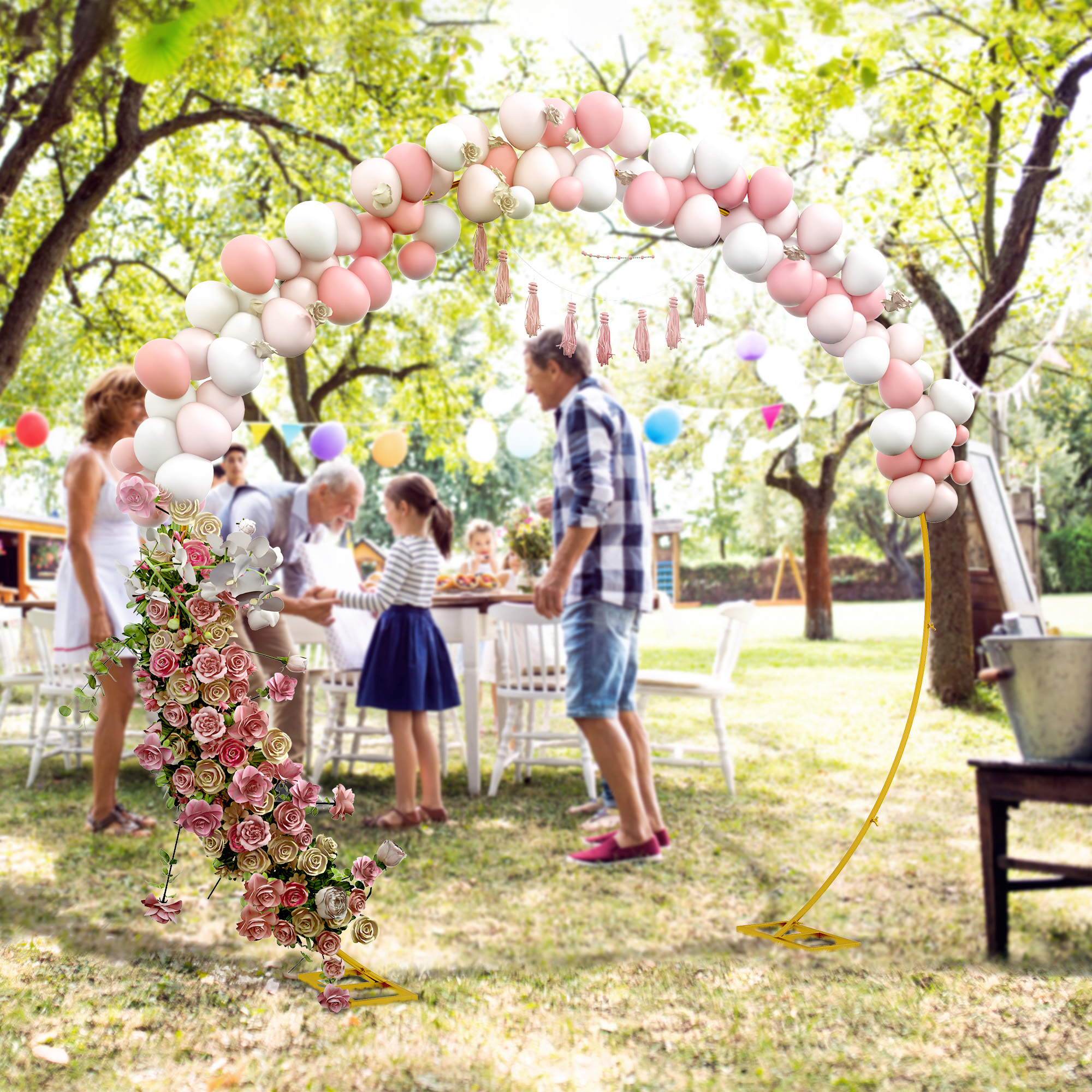 Festa in giardino con arco di palloncini, fiori e ospiti a tavola.
