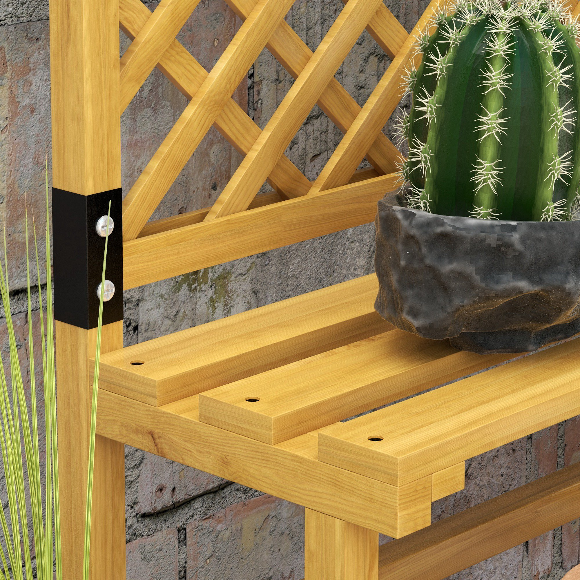 Panchina in legno con cactus in vaso ed erba davanti a un muro di mattoni.