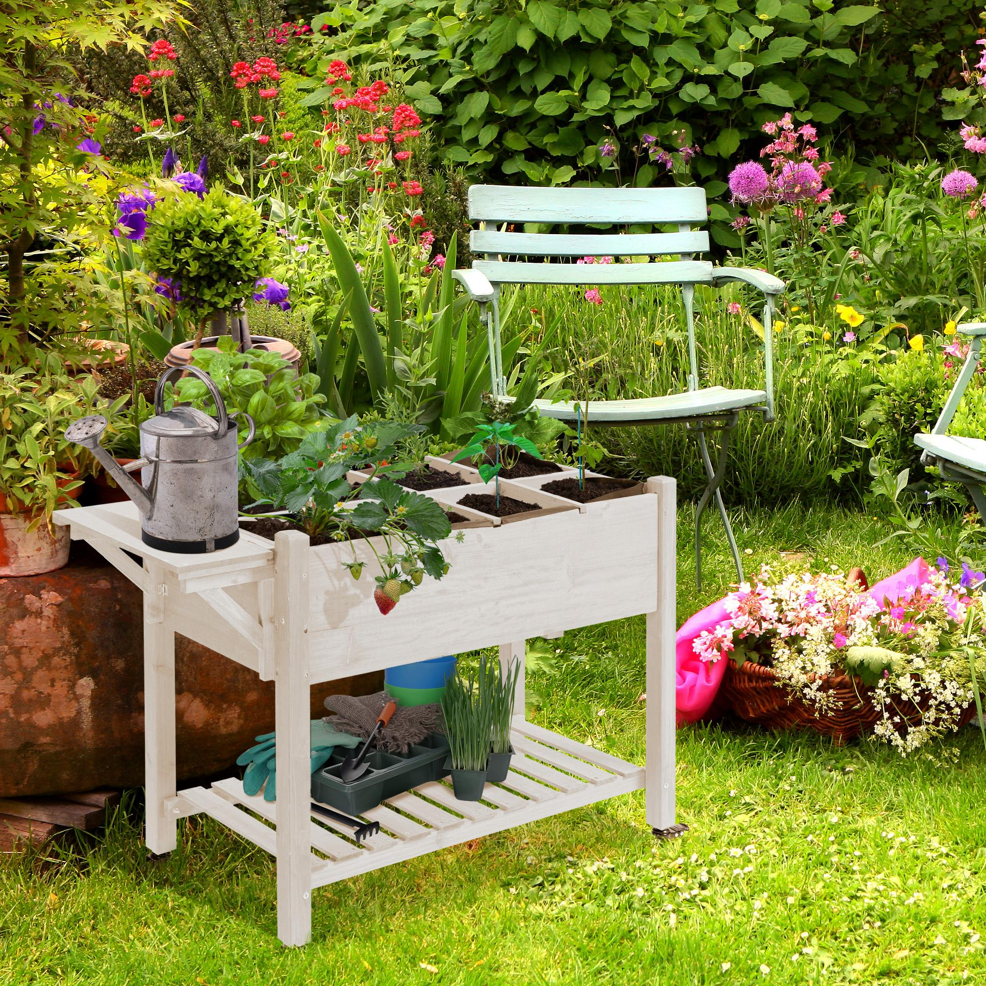 Un banco da giardinaggio in legno in un giardino con attrezzi, annaffiatoio e fragole.